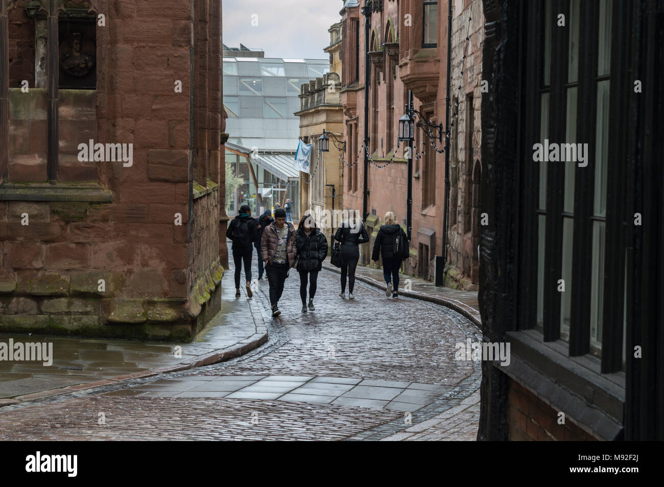 I membri del pubblico a piedi giù per la strada basolata di Bayley Lane intorno alla vecchia area di Coventry City Centre Foto Stock