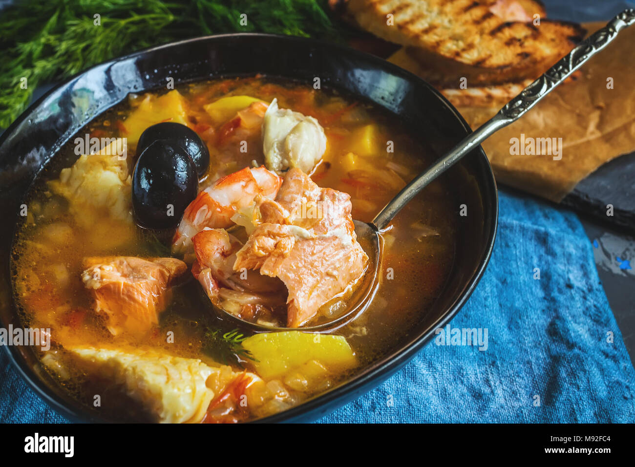 Il francese di una zuppa di pesce bouillabaisse con pesce e frutti di mare, il filetto di salmone e gamberetti, ricchi di sapore, deliziosa cena. Close up. Foto Stock
