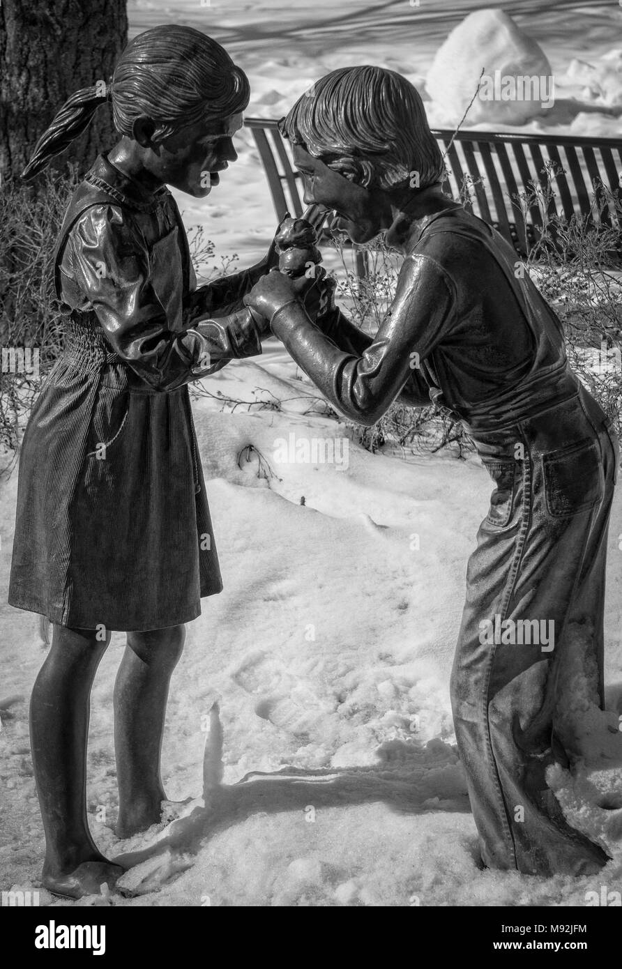 Ragazzo e una ragazza a mangiare il gelato statua in bronzo al di fuori del Conservatorio ENMAX presso lo Zoo di Calgary Alberta Canada Foto Stock