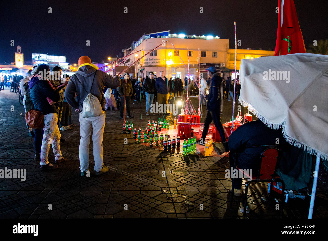 Persone a giocare il gioco da pesca di soft drink bottiglie sulla piazza centrale di Jemma El Fnaa a Marrakech in Marocco Foto Stock