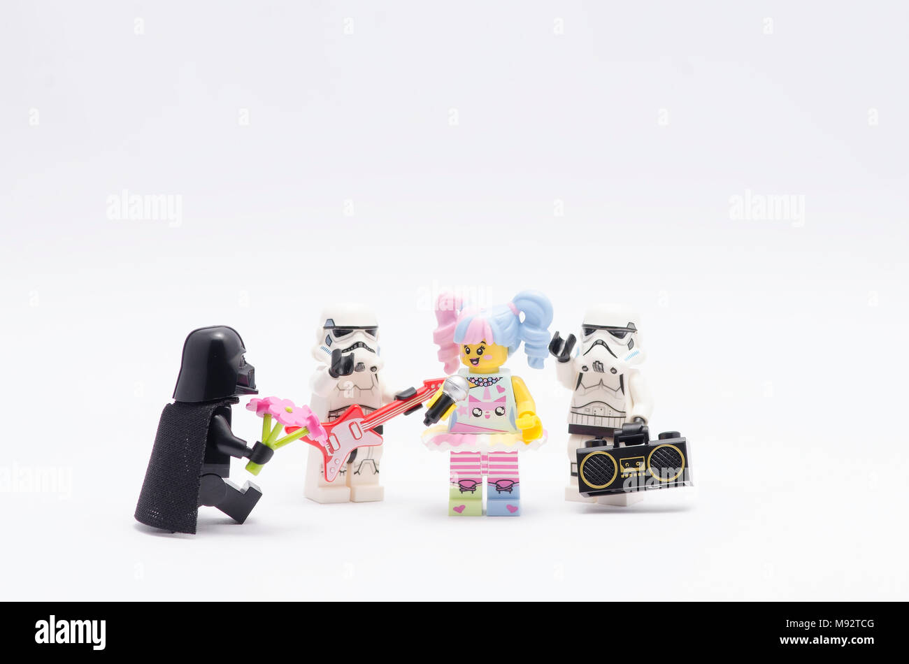 Lego Darth Vader dando fiore a n-pop ragazza con storm troopers, isolato su sfondo bianco. Foto Stock