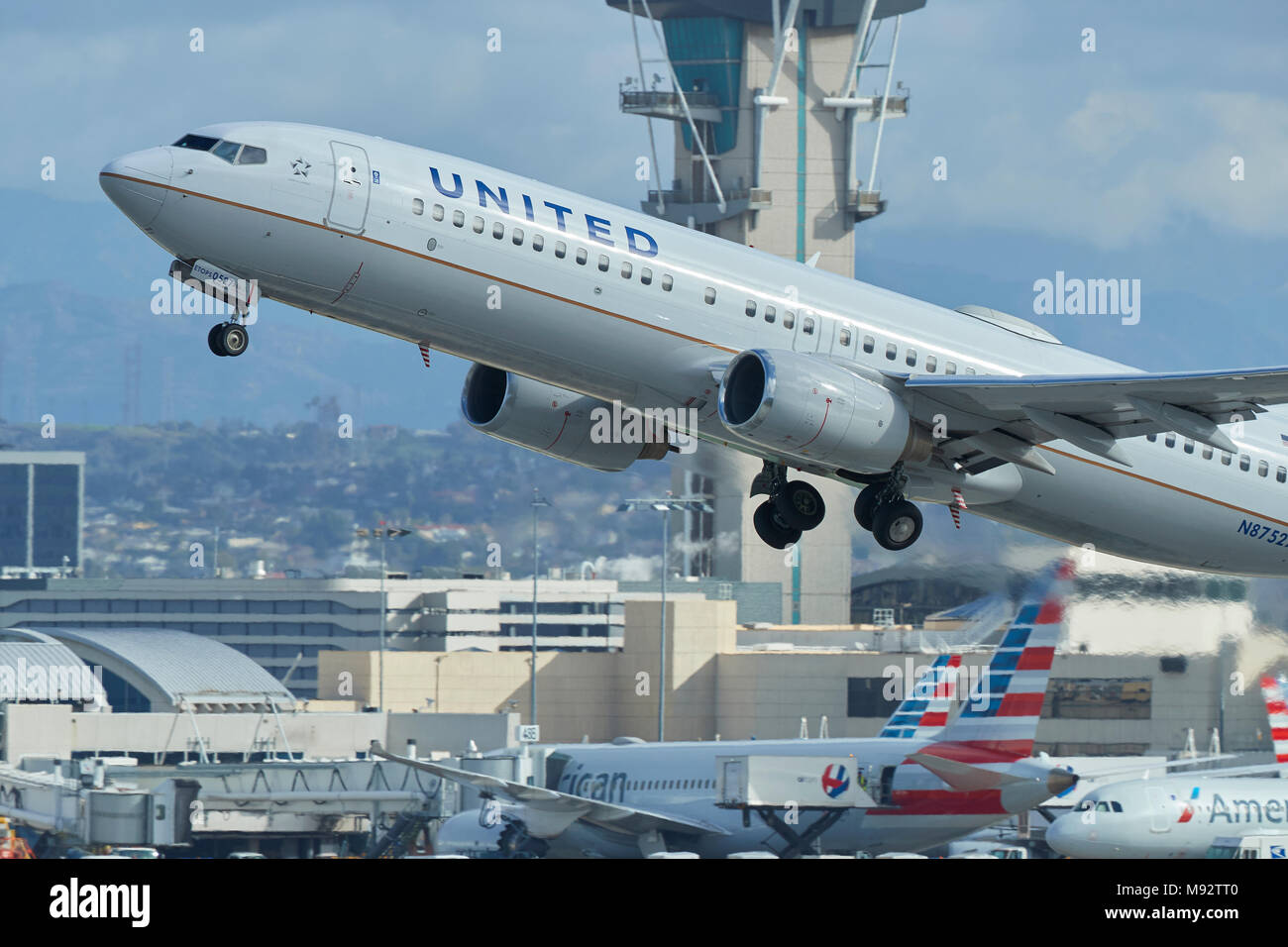 Vicino la foto di un United Airlines Boeing 737-800 aereo Jet decollo dall'Aeroporto Internazionale di Los Angeles LAX, la torre di controllo dietro. Foto Stock