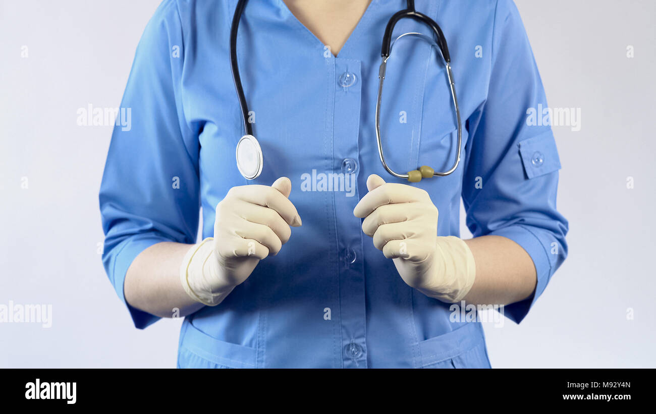 Operatore sanitario in uniforme e guanti di gomma, esame del paziente, analisi Foto Stock