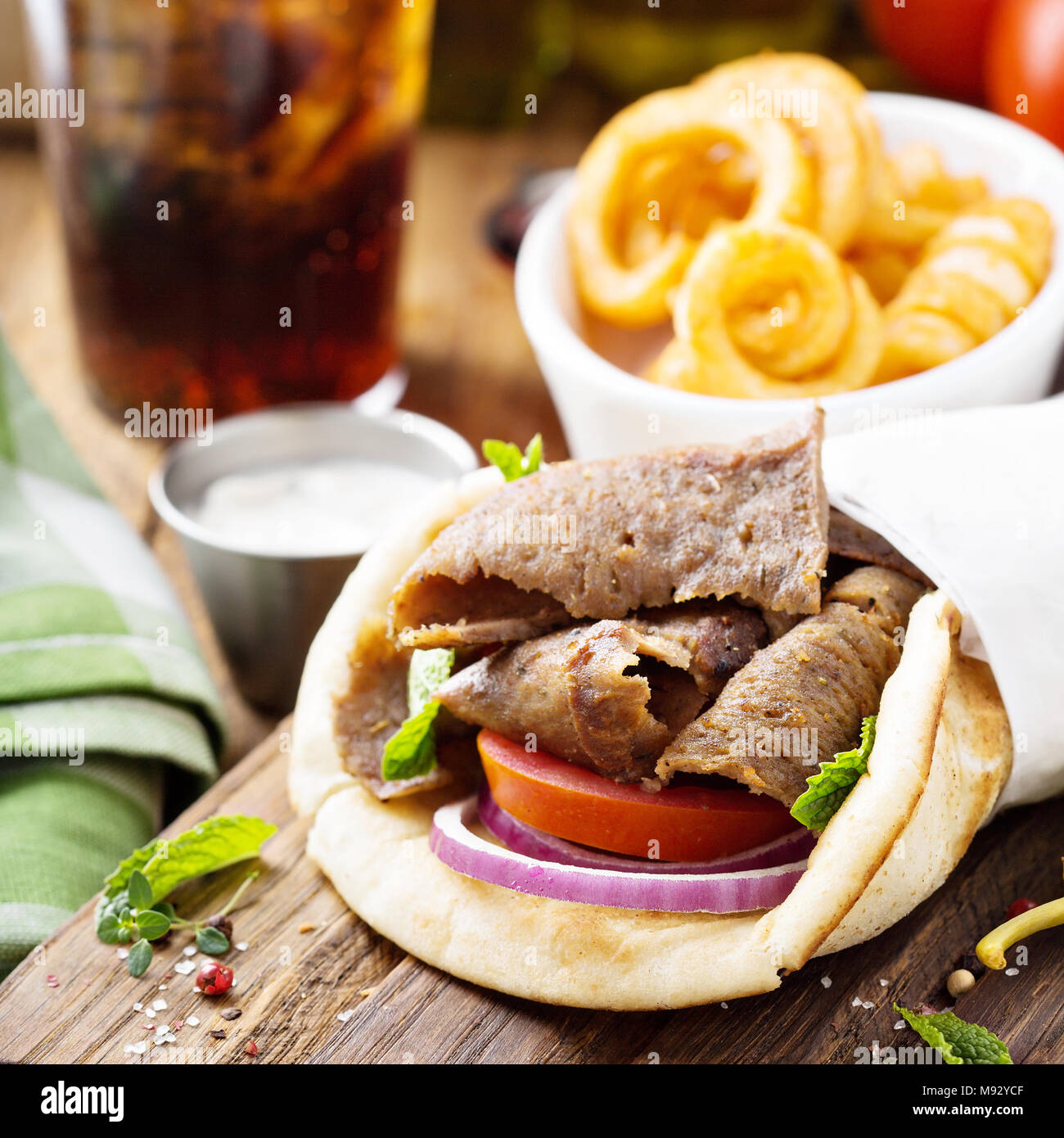 Gyro greco pita avvolgere con patatine fritte ricci Foto Stock