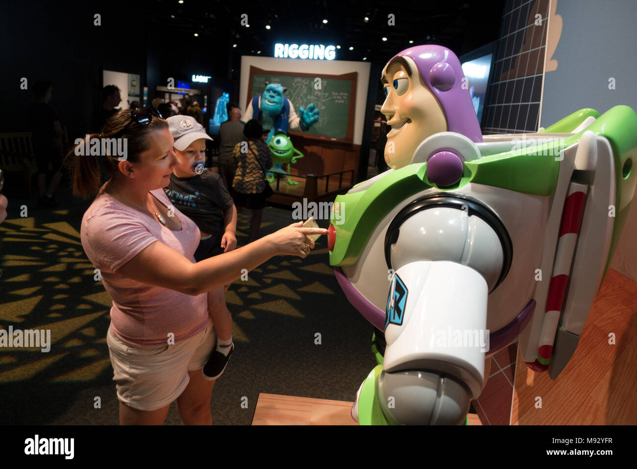 Mom spinge Buzz Lightyear di pulsanti informativo presso la "la scienza dietro Pixar' mostra al Museo della Scienza del Minnesota. St Paul Minnesota MN USA Foto Stock