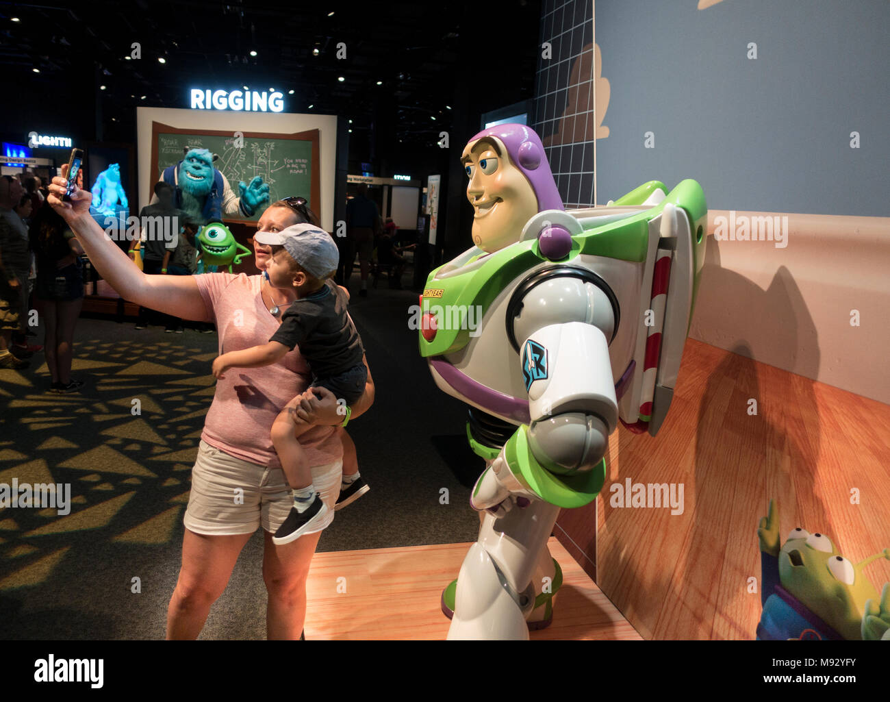 La mamma prende selfie con figlio e Buzz Lightyear Toy Story film 'La scienza dietro Pixar' presentano il Museo della Scienza del Minnesota. St Paul Minnesota MN USA Foto Stock