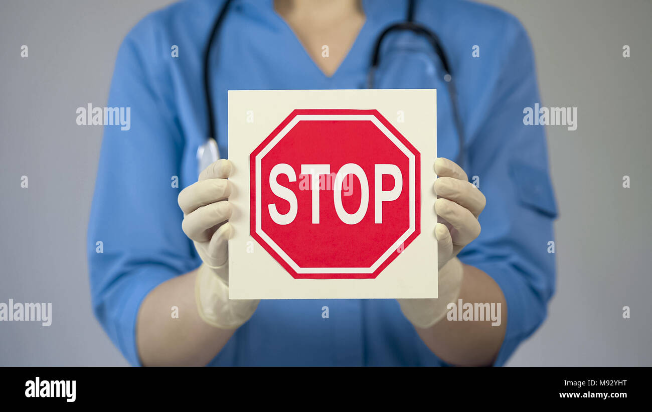 Medico tenendo premuto STOP, avvertimento su uno stile di vita poco salutare, abitudini nocive Foto Stock