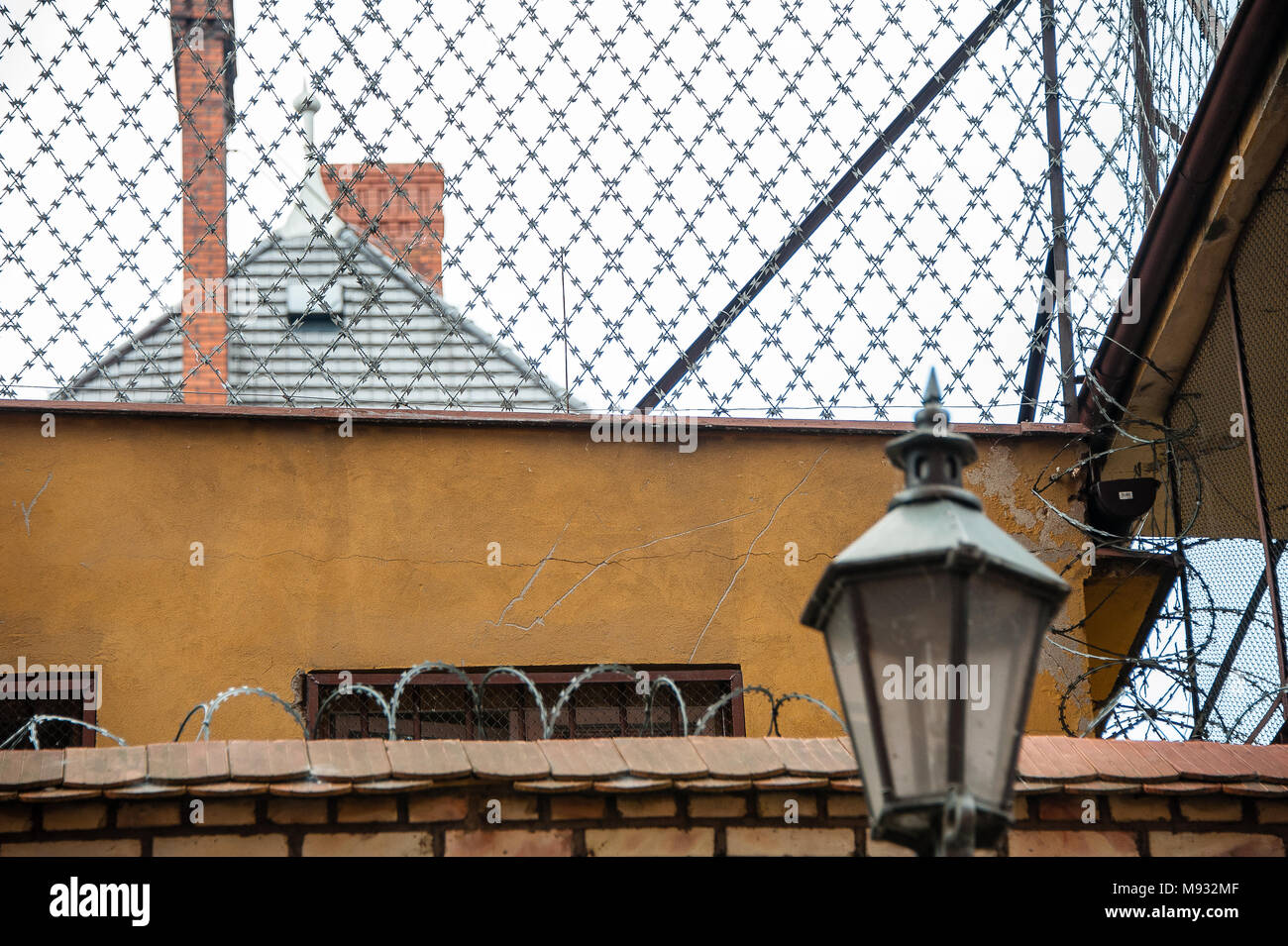Le misure di sicurezza attorno ad un centro di detenzione in costruzione Torun, Polonia. Filo spinato e alto muro vista sul tetto Foto Stock