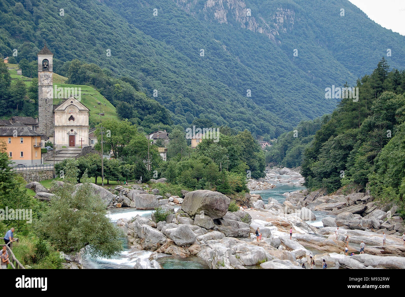 Turisti tra levigata liscia di rocce e massi nel fiume Verzasca (Fluss) - Lavertezzo, in Val Verzasca, Svizzera Foto Stock