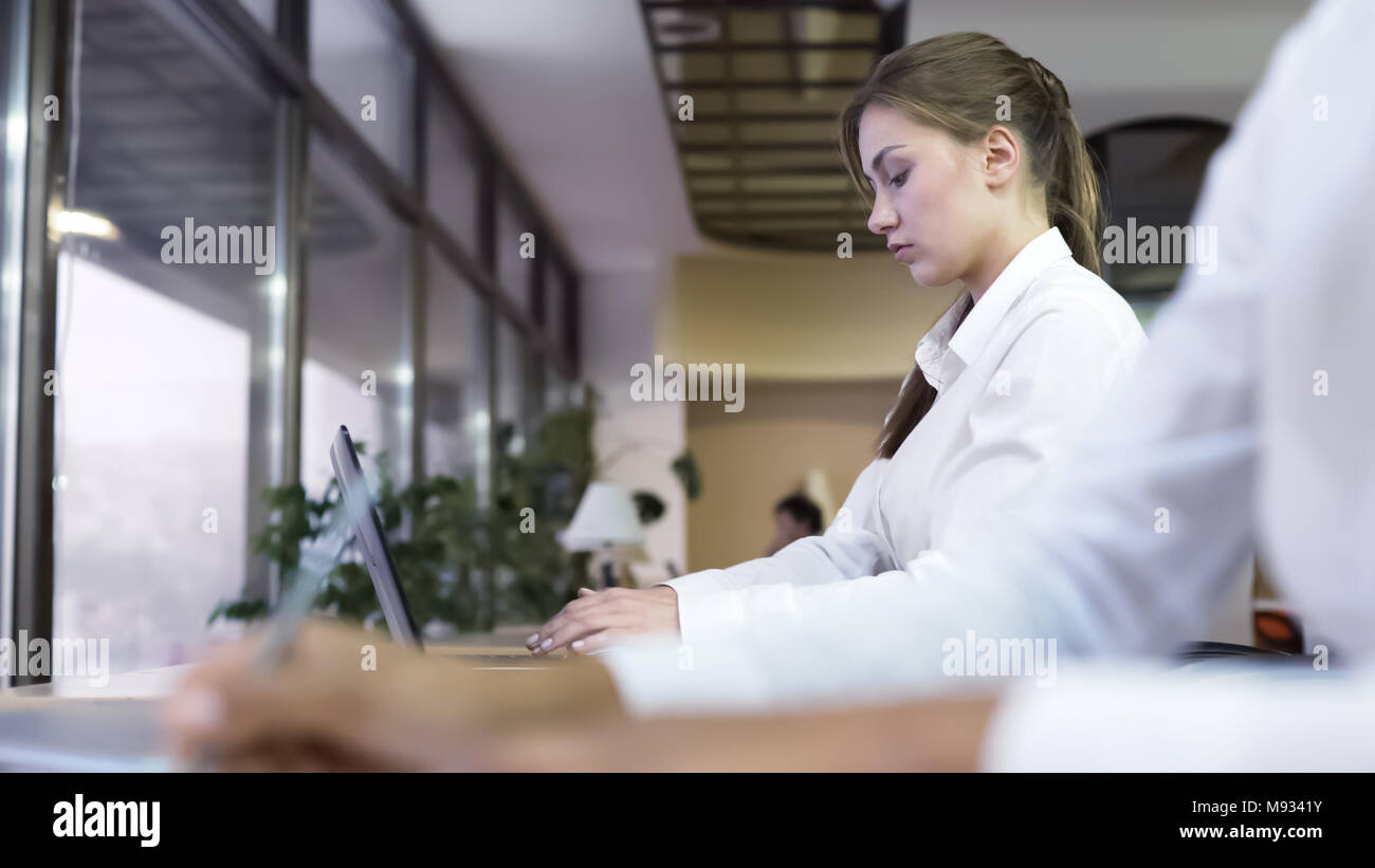 Business persone che lavorano in ufficio, donna attraente rapporto di digitazione sul computer portatile Foto Stock