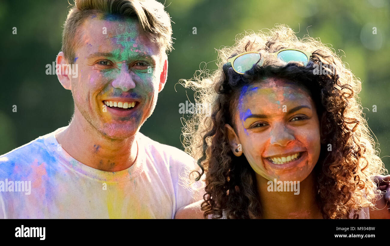 Coppia sorridente avendo divertimento fuori sul colore parte celebrazione, godendo di festival Foto Stock Coppia sorridente avendo divertimento fuori sul colore parte celebrazione, godendo di festival Foto Stock
