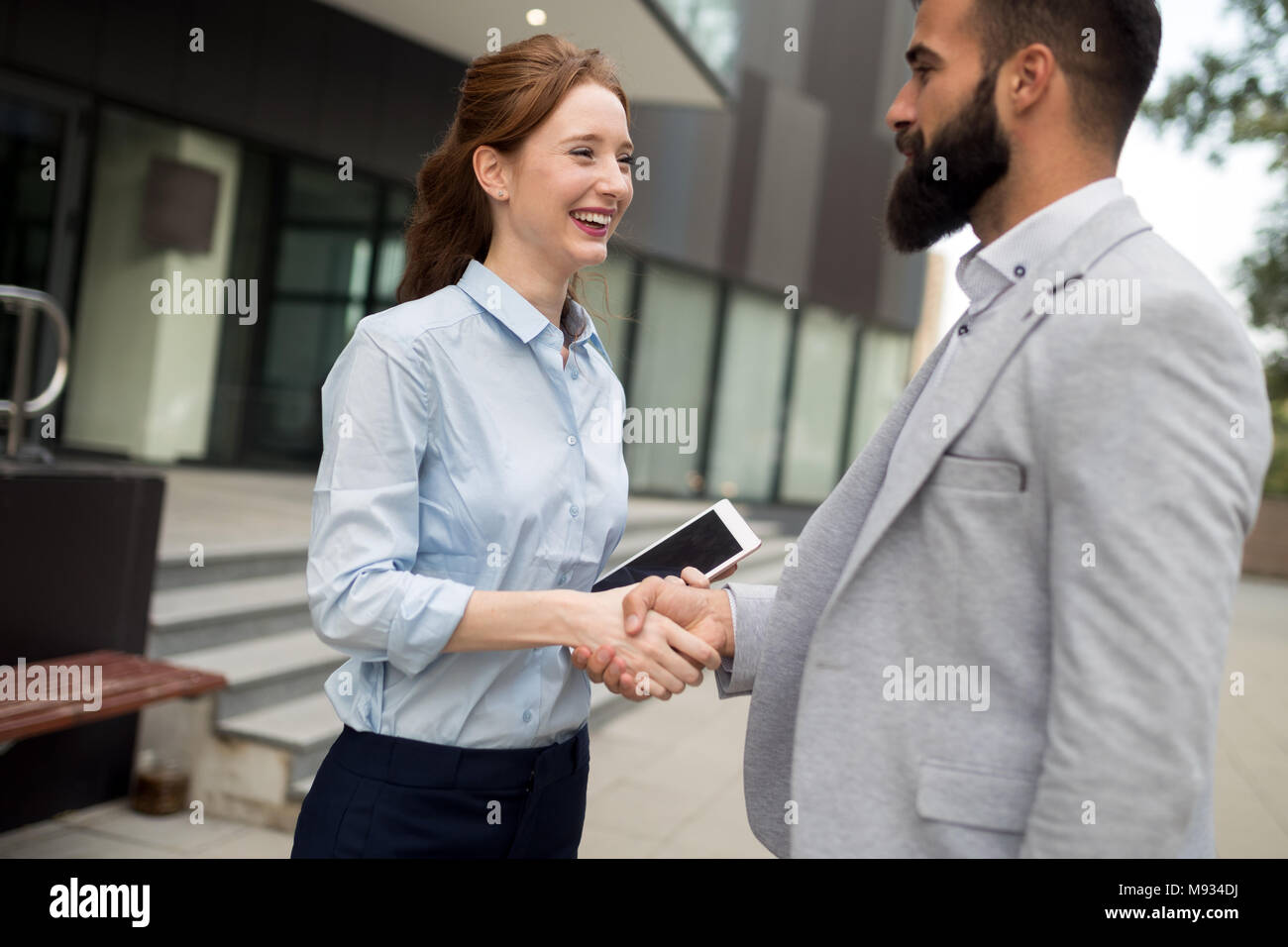 Business e concetto di ufficio. Imprenditore e imprenditrice stringono le mani Foto Stock