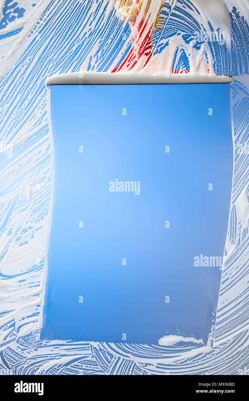 La finestra di pulizia con spatola cielo blu Foto Stock