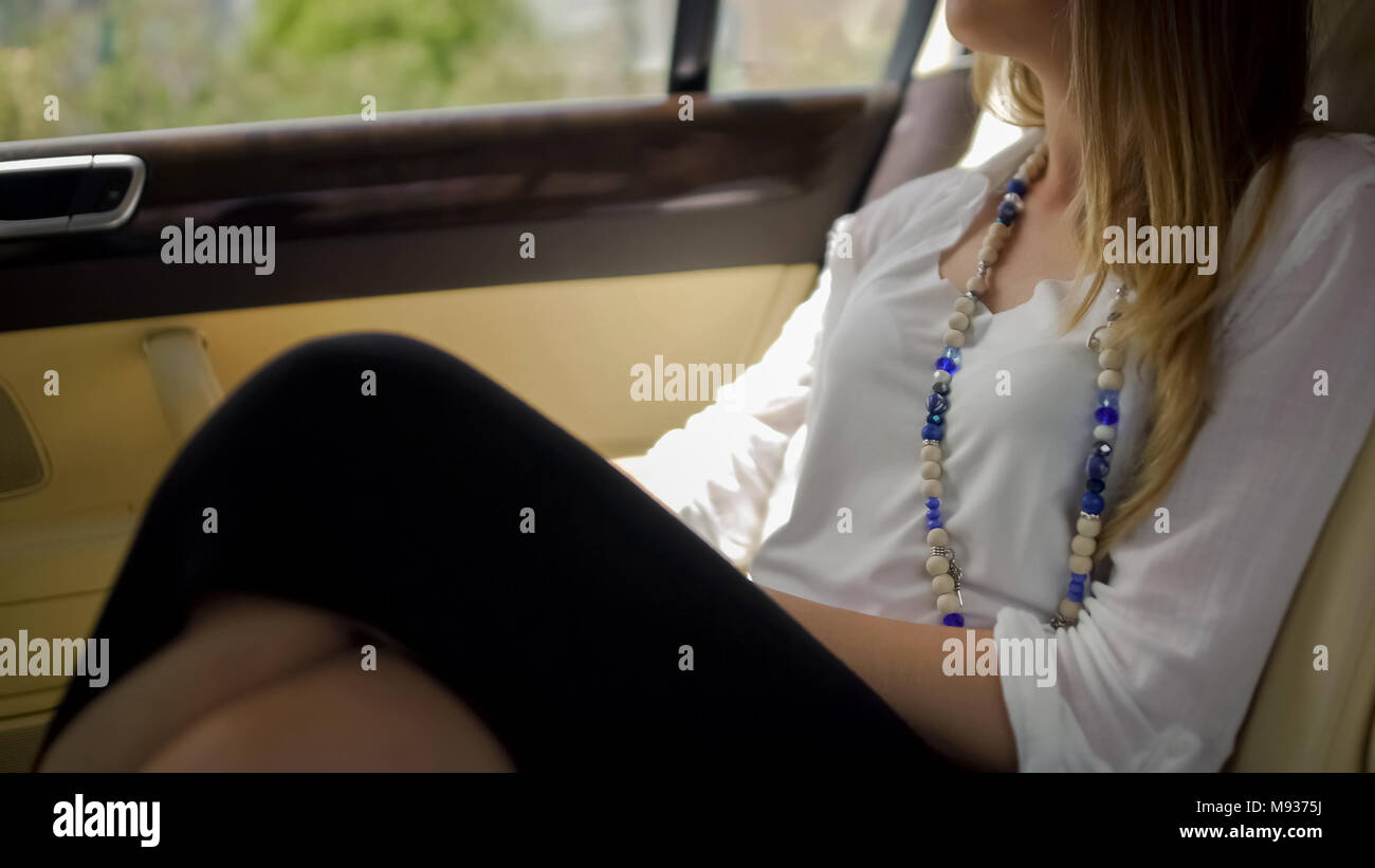 Ricca donna seduta in auto di lusso e godere il paesaggio, la tanto attesa vacanza Foto Stock