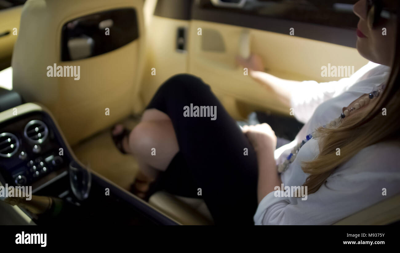 Imprenditrice di successo in seduta costosa auto, lo stile di vita di lusso, vacanze Foto Stock