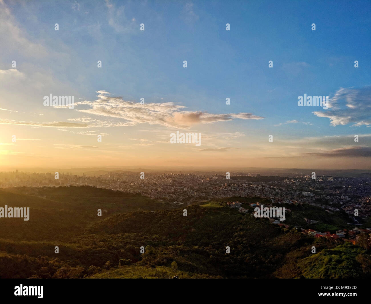 Vista dalla cima della città di Belo Horizonte e le sue colline, valli, e edifici durante il tramonto nelle montagne di Curral Foto Stock