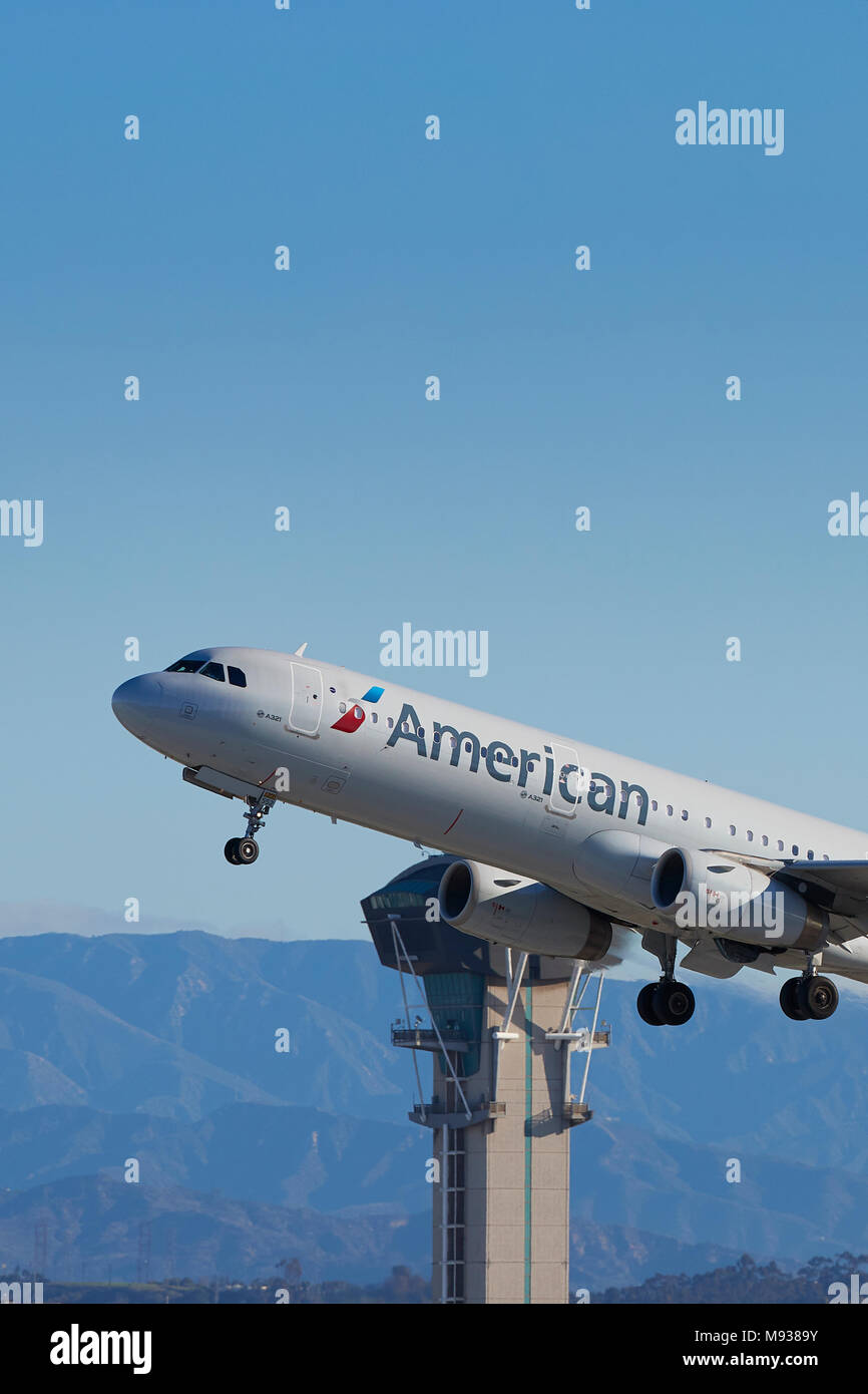 American Airlines Un Airbus A321 aereo di linea, decollo dall'Aeroporto Internazionale di Los Angeles LAX, la torre di controllo e montagne di San Gabriel dietro. Foto Stock