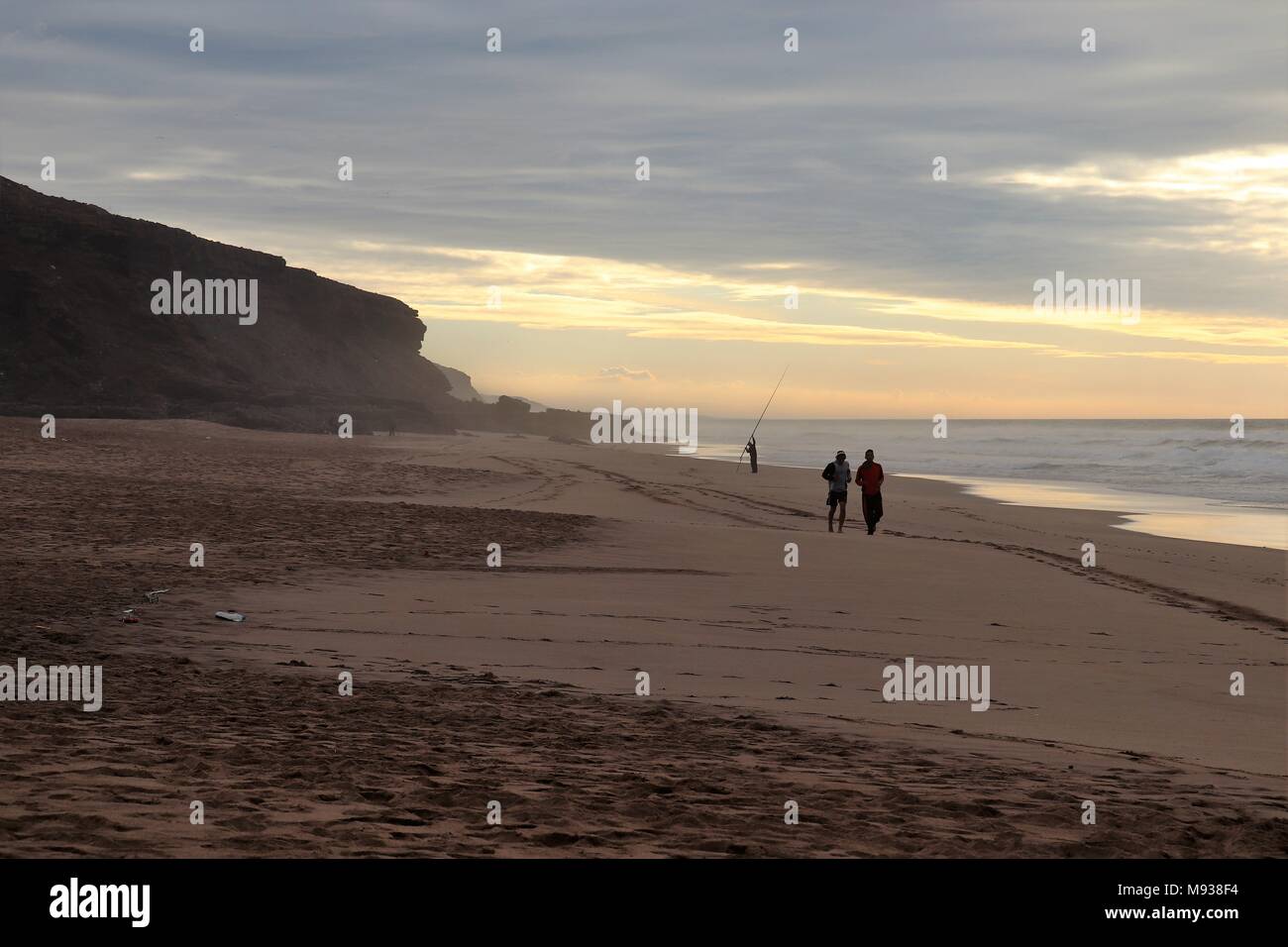 Due guide di scorrimento sulla spiaggia di Plage des Nations, con un polo pescatore dietro, il tramonto e il crepuscolo Foto Stock