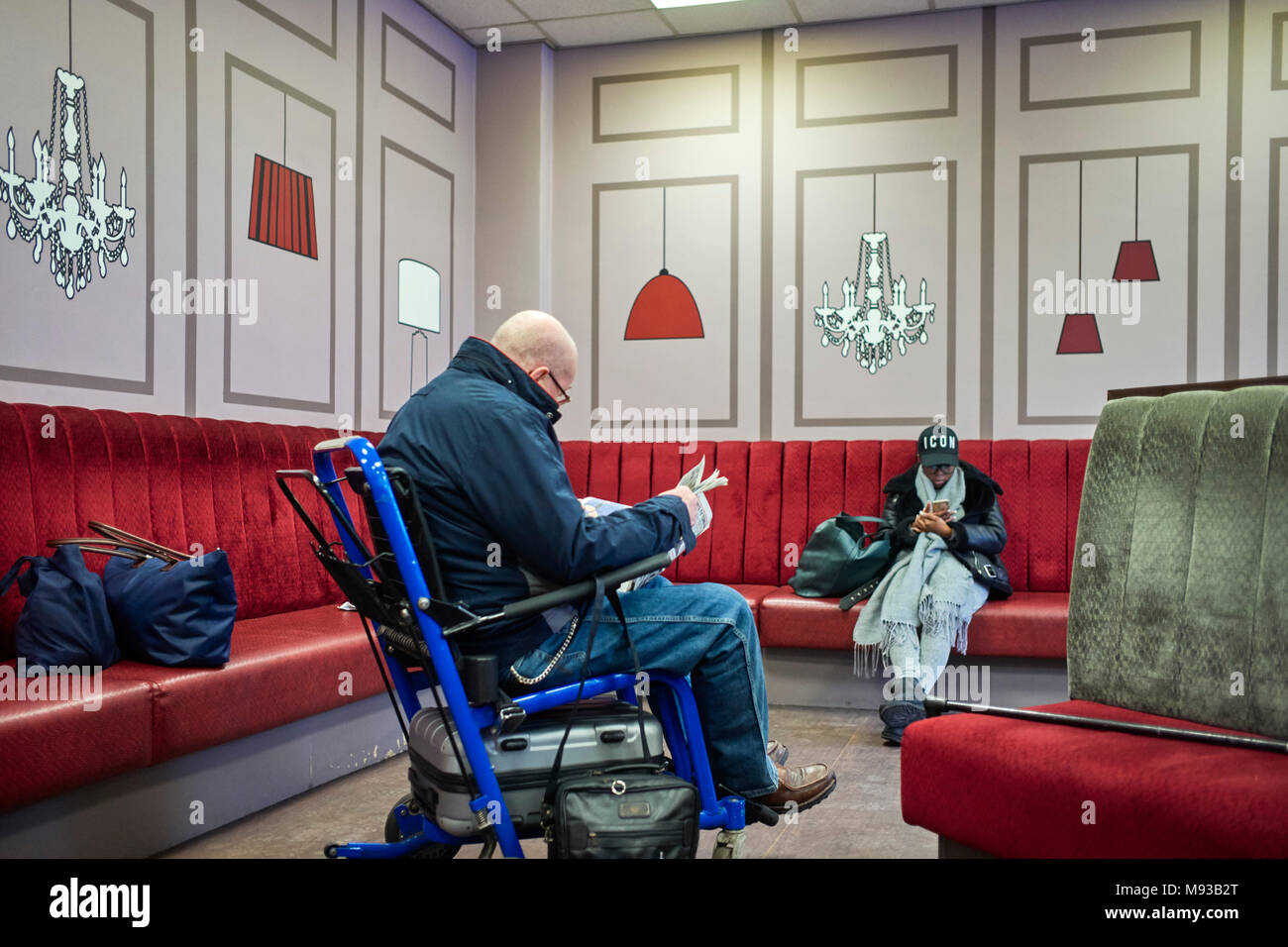 Un passeggero disabile in attesa di essere aiutato su un treno alla stazione di Crewe sala di attesa Foto Stock