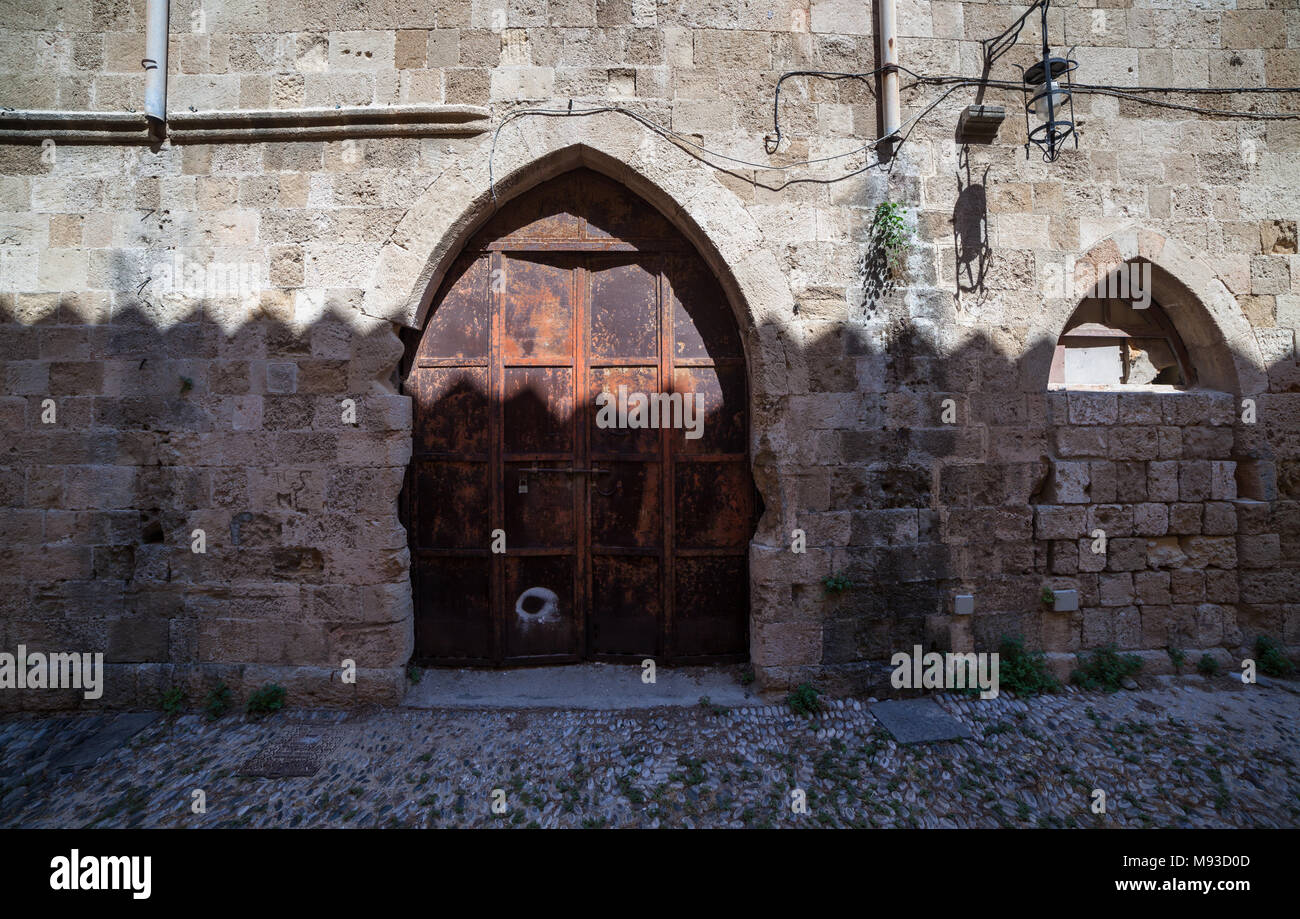 Merlato, visto-come ombra sul muro di un edificio nella città vecchia di Rodi Foto Stock