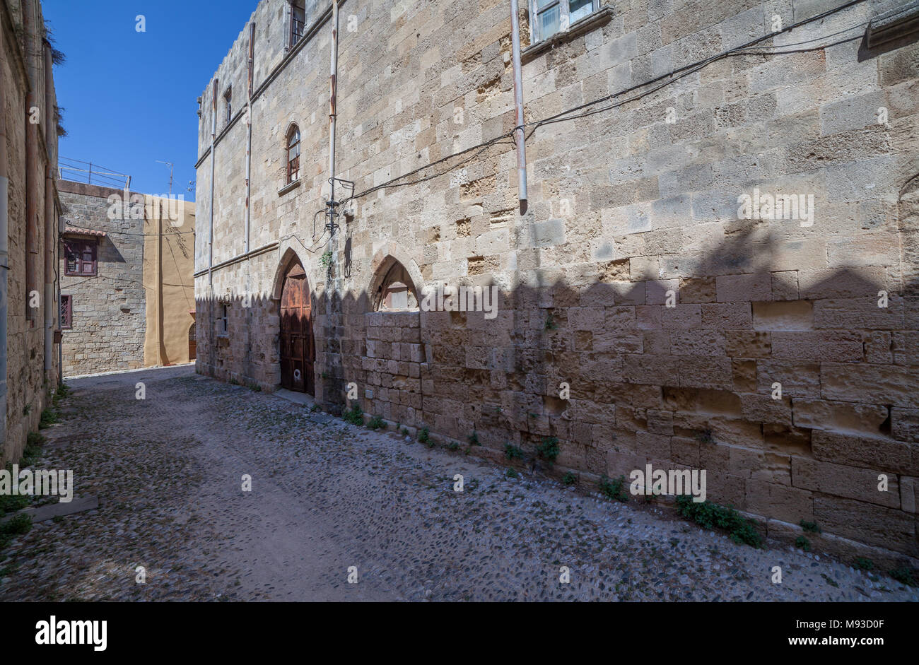 Merlato, visto-come ombra sul muro di un edificio nella città vecchia di Rodi Foto Stock