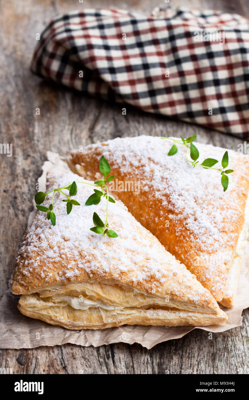 Pane appena sfornato fatturati con crema bianca sul tavolo di legno Foto Stock