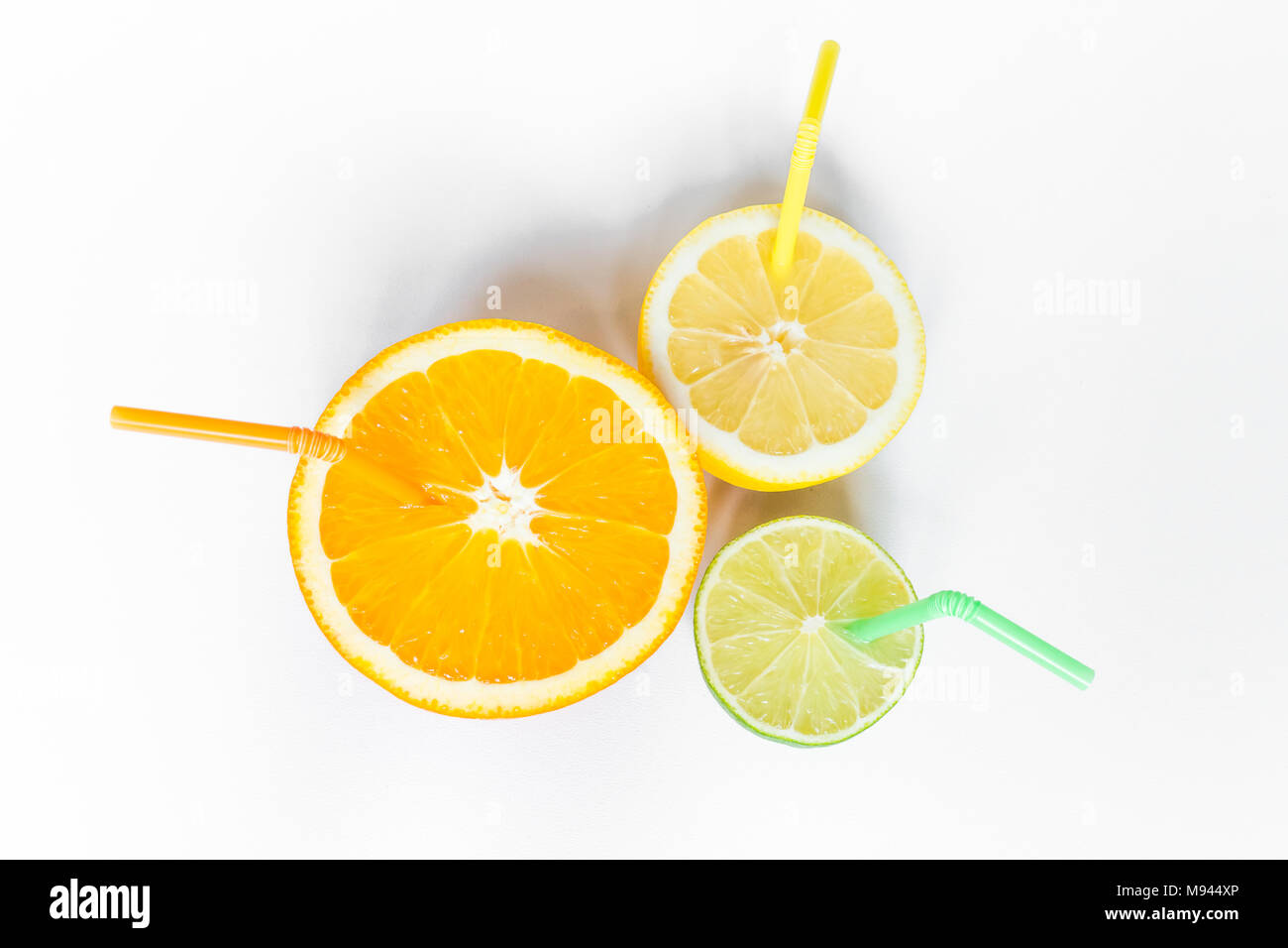 Agrumi con giallo arancione e verde cannucce su sfondo bianco dal di sopra Foto Stock