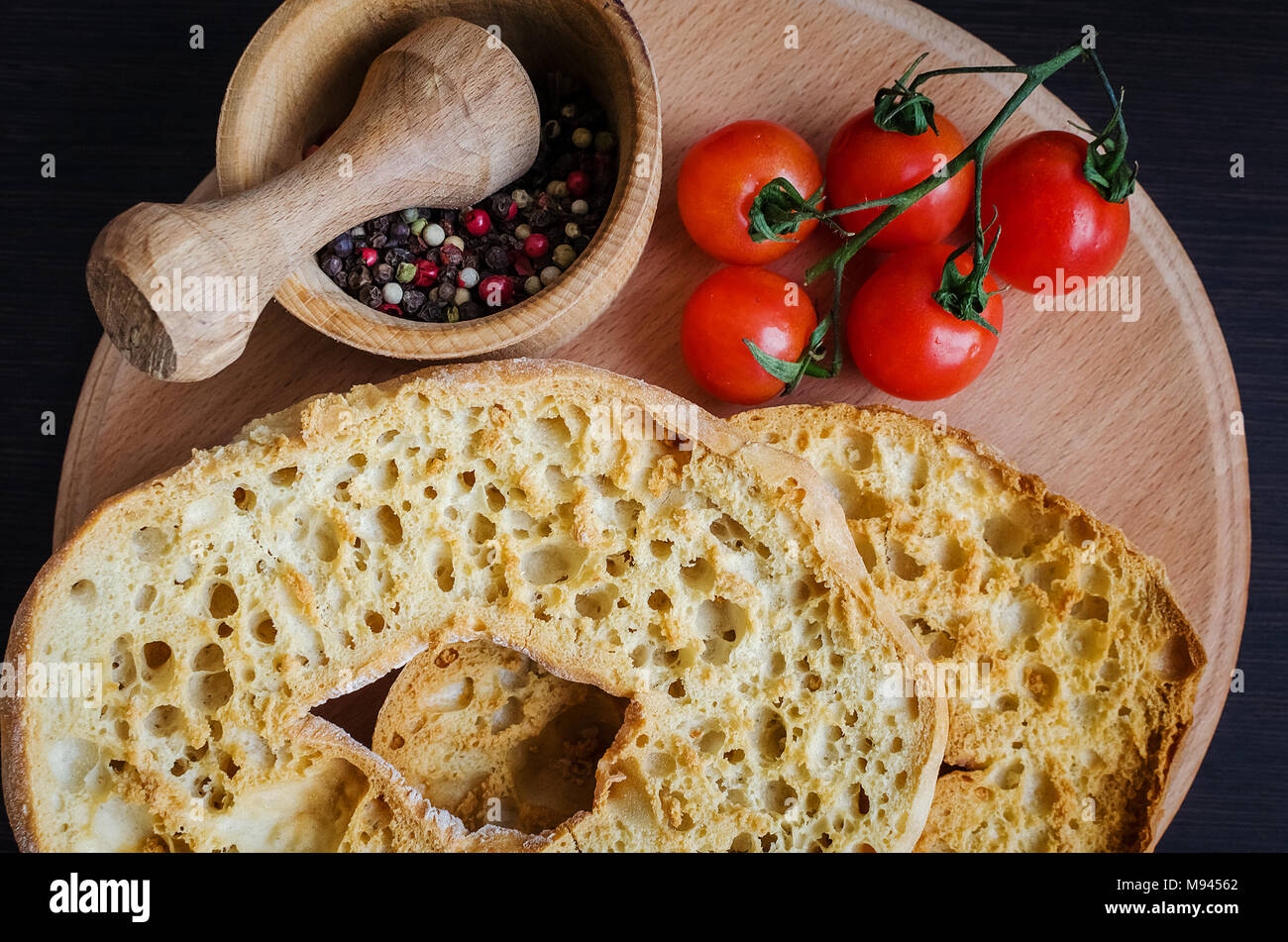 Italiano di pane secco Friselle sulla tavola di legno con pomodori ciliegia e pepe. Il cibo italiano. Una sana alimentazione vegetariana. Foto Stock