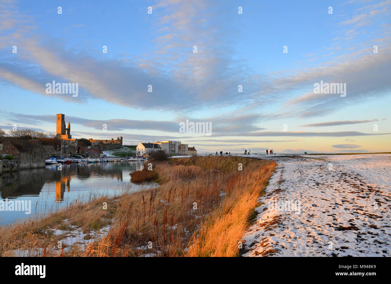Inverno nevoso vista di St Andrews Harbour e Cattedrale dall'orlo della east sands in Fife, Scozia Foto Stock