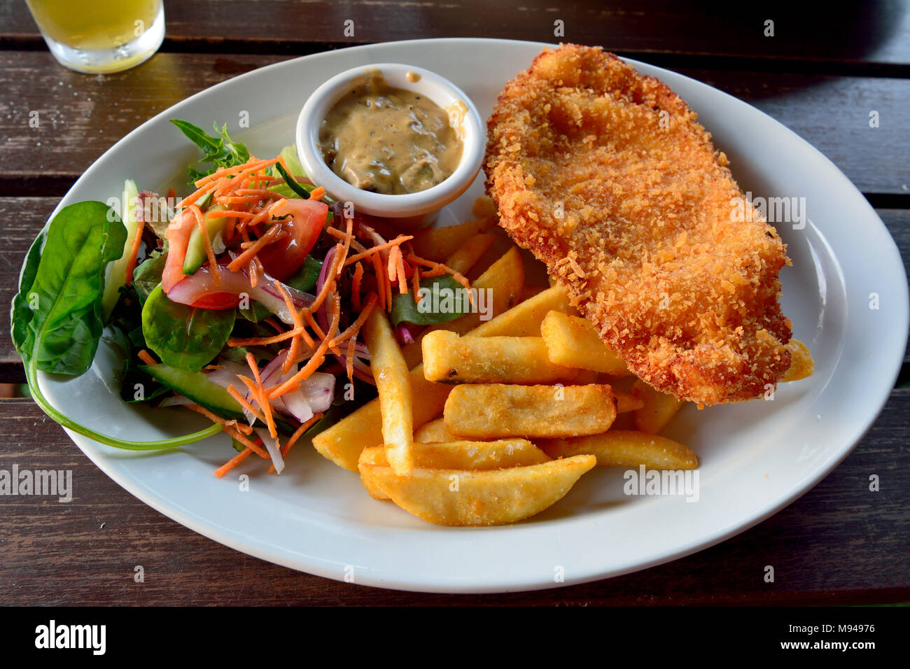 Cotoletta con insalata, sugo di funghi e patatine fritte Foto Stock