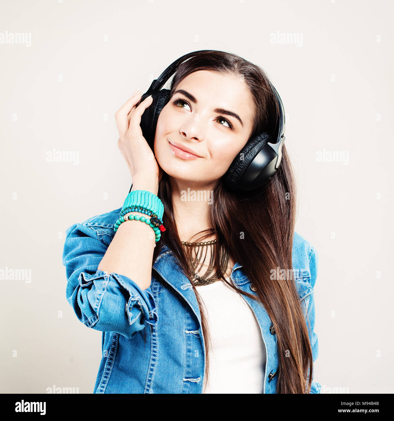 Felice ragazza godendo la musica e guardando verso l'alto. Giovane bella donna con gli auricolari Foto Stock