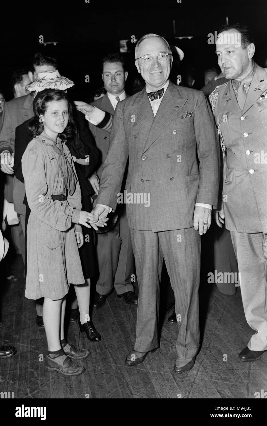 Il presidente Harry Truman scuote le mani con una ragazza in uniforme Scout durante una visita a Kansas City subito dopo aver prestato giuramento di office nel 1945. Foto Stock