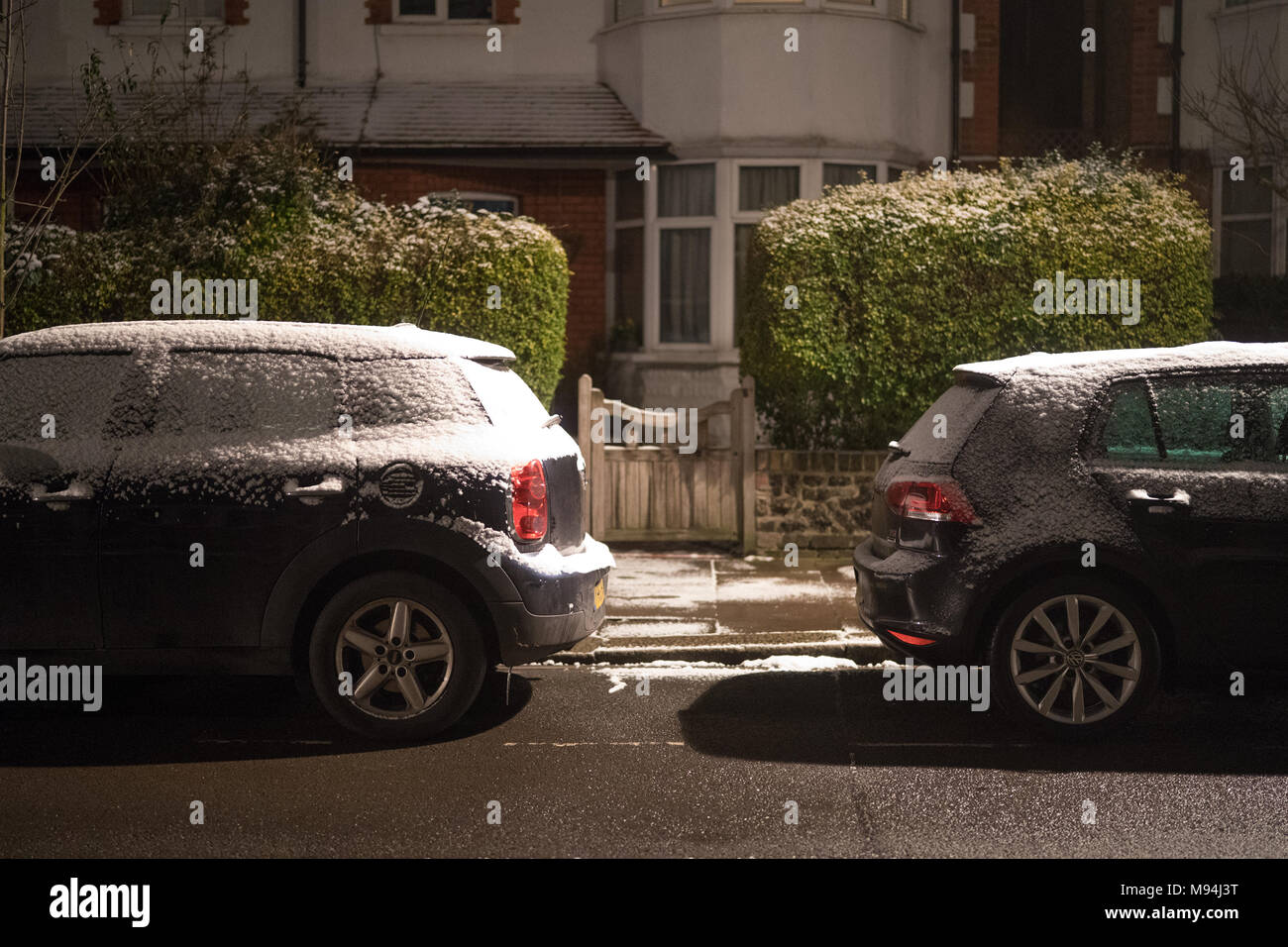 Auto su una strada suburbana a Londra dopo una leggera caduta di neve. Da una serie di immagini di strade di Ealing durante un freddo snap a Londra. P Foto Stock