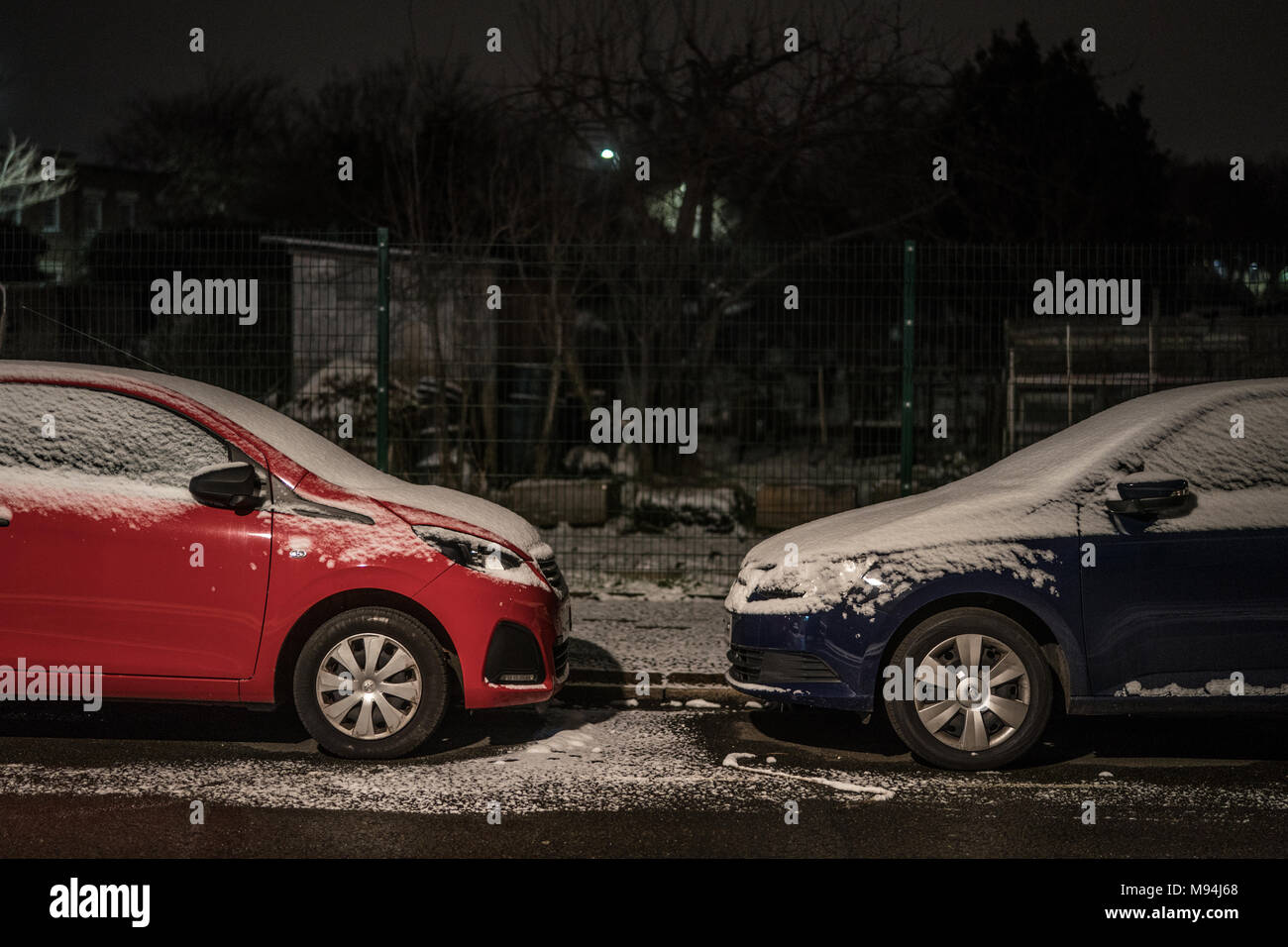 Auto su una strada suburbana a Londra dopo una leggera caduta di neve. Da una serie di immagini di strade di Ealing durante un freddo snap a Londra. P Foto Stock