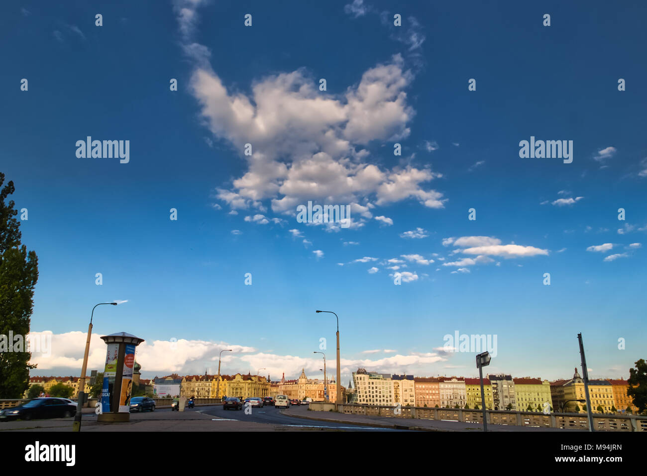 Praga, Repubblica Ceca - 27 agosto 2014: il sole illumina la Casa Danzante mentre le auto si muovono sul ponte di Praga Foto Stock