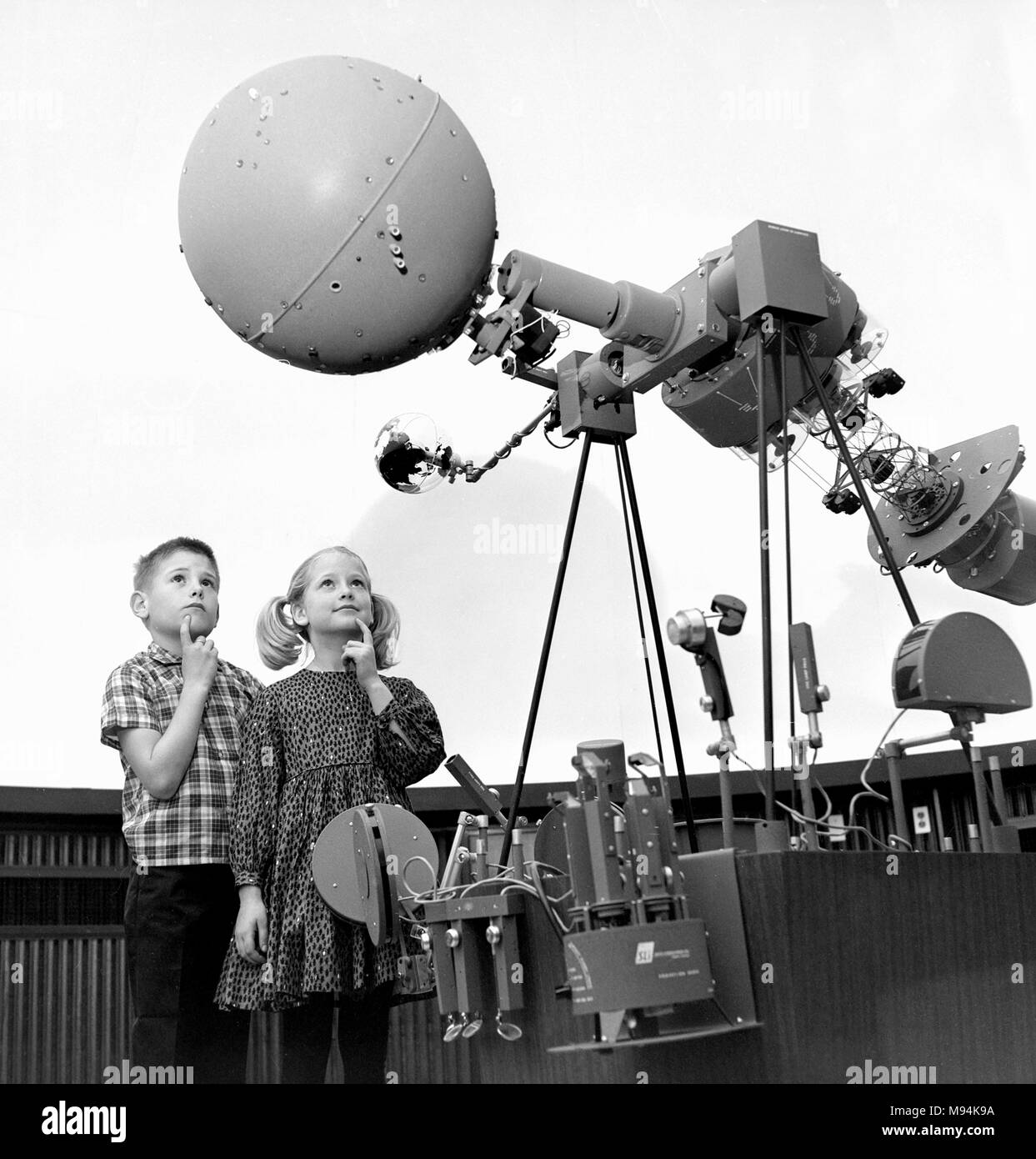 Due bambini in età scolare fisso lo sguardo su di un proiettore del planetario mentre su un campo della scienza viaggio in California, ca. 1966. Foto Stock