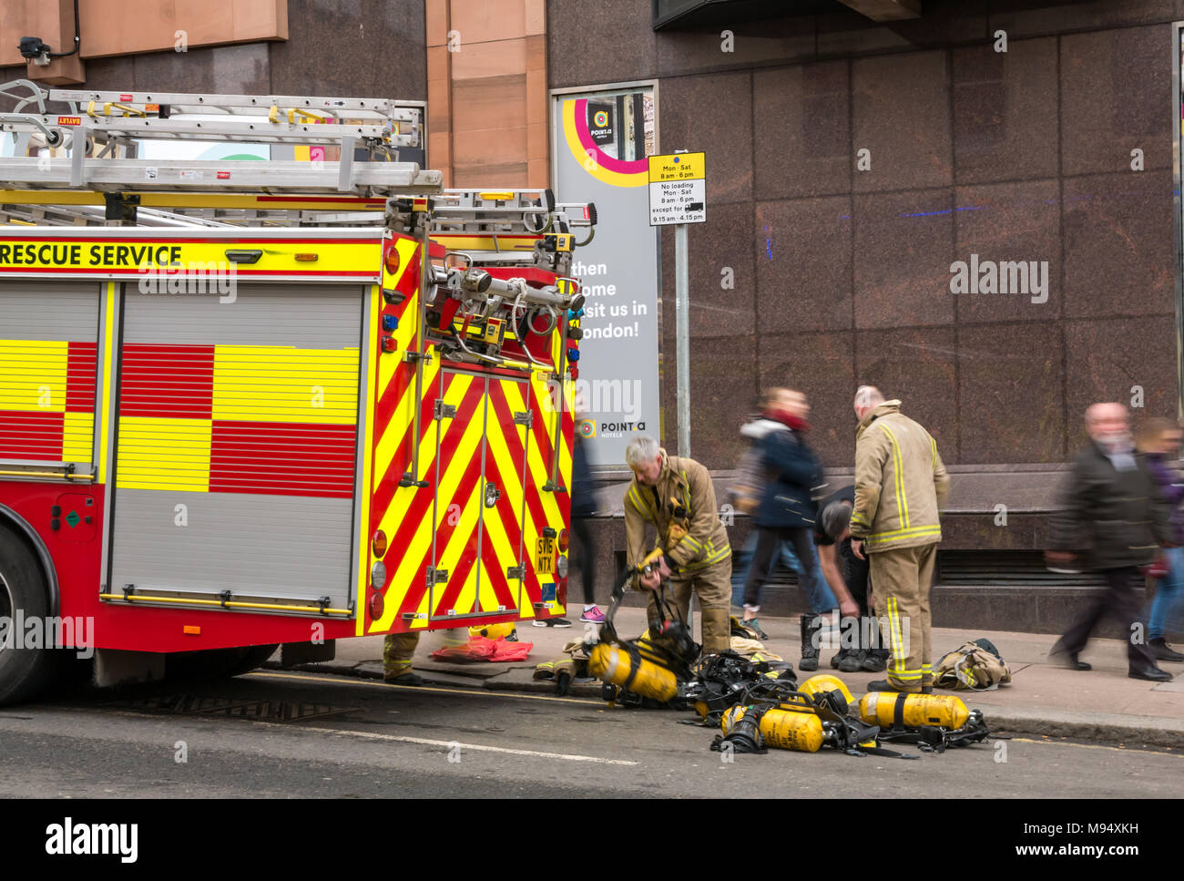 Bath Street, Glasgow, Scotland, Regno Unito, 22 marzo 2018. Un grave incendio che coinvolga più edifici chiude strade nella zona centrale di Glasgow. Stanchi dei vigili del fuoco prevedere apparecchi di respirazione nella strada accanto ad un motore Fire Foto Stock