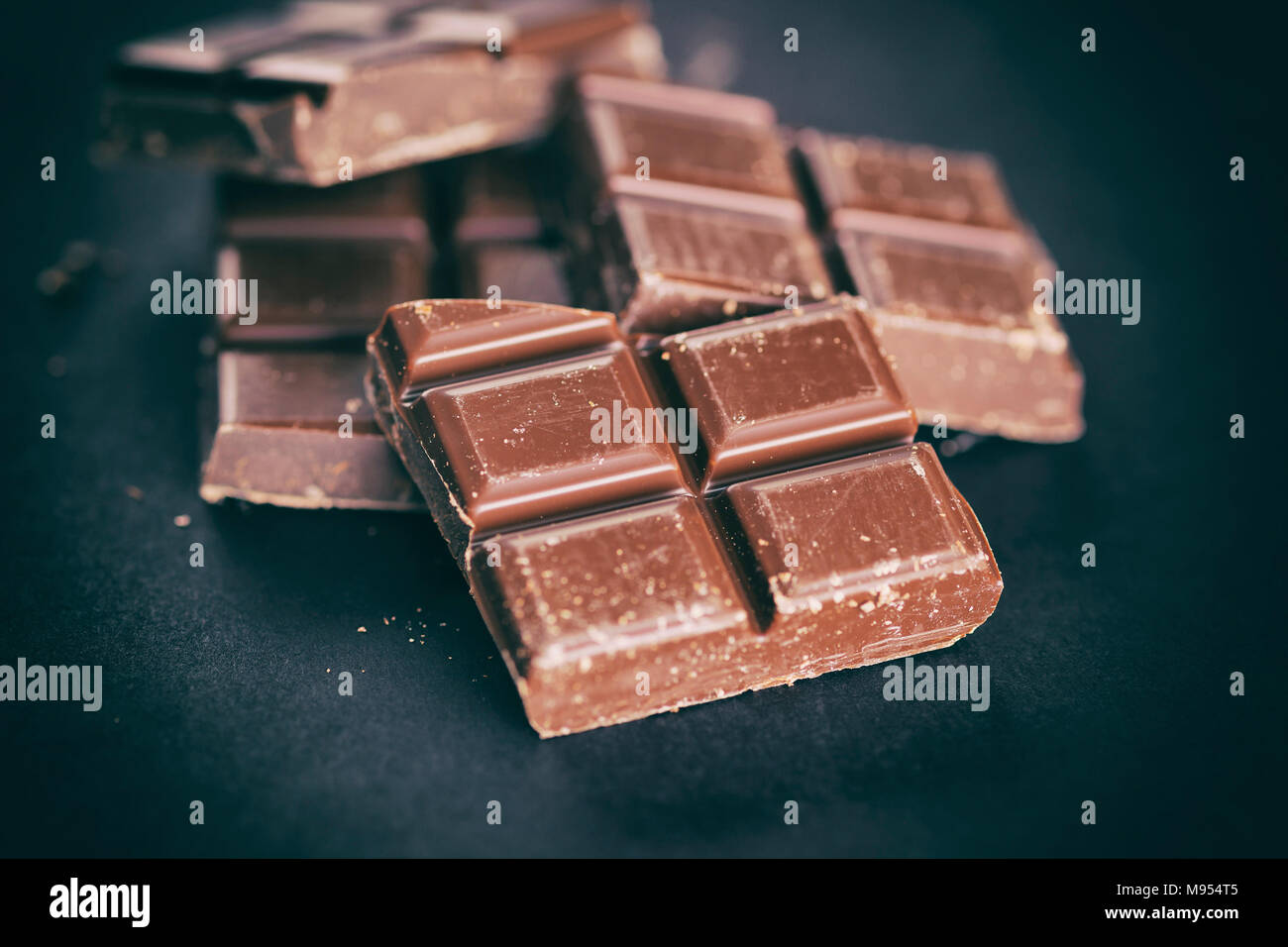 Rotture di marrone a pezzetti di cioccolato. Sfondo nero. Close up. Foto Stock