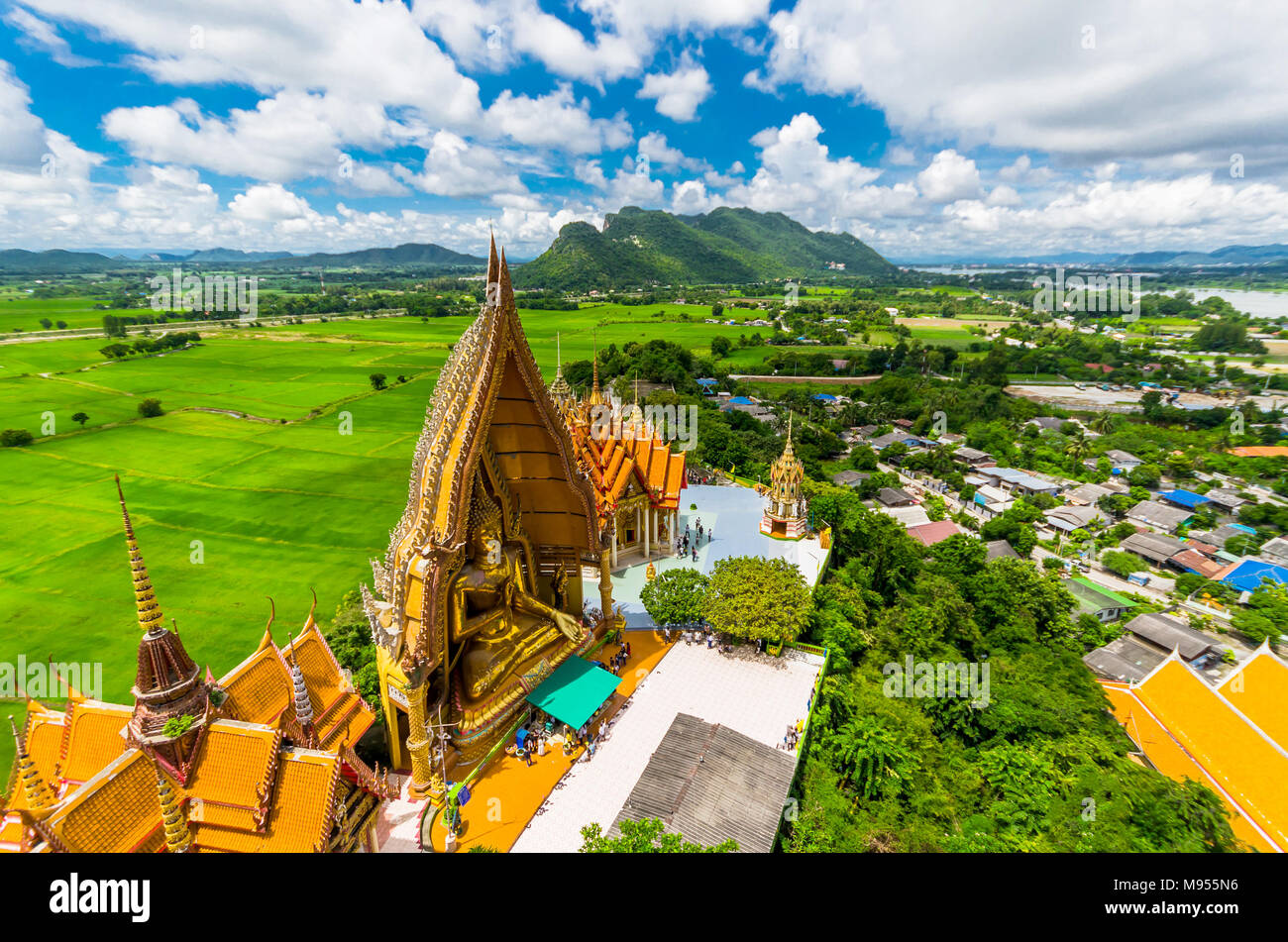 La vista dalla cima della pagoda dorata, statua del Buddha con i campi di riso e la montagna, Tiger tempio nella grotta (Wat Tham Seua) Thai e templi Cinesi in K Foto Stock