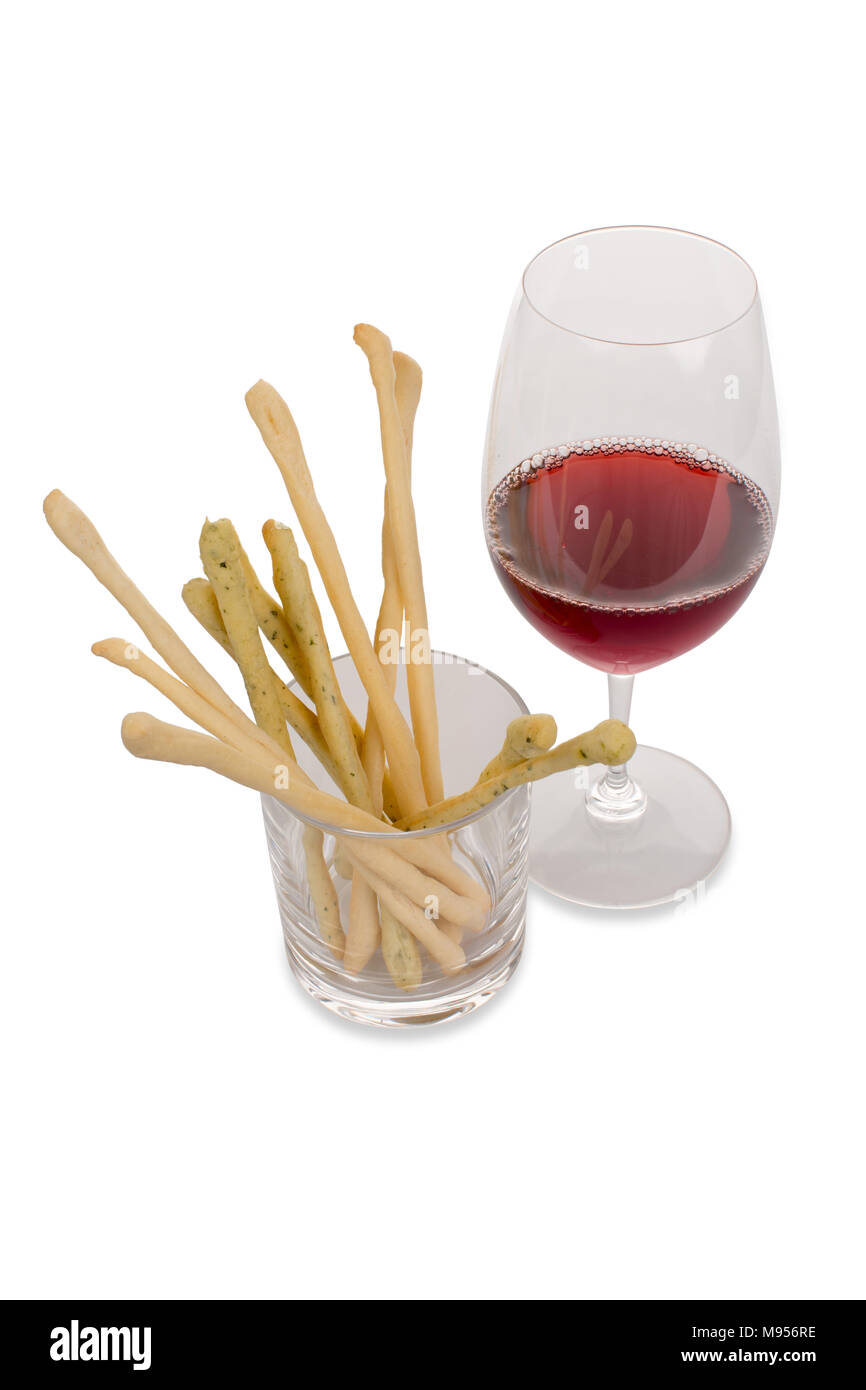 Un bicchiere di vino rosso con bastoncini di pane Foto Stock