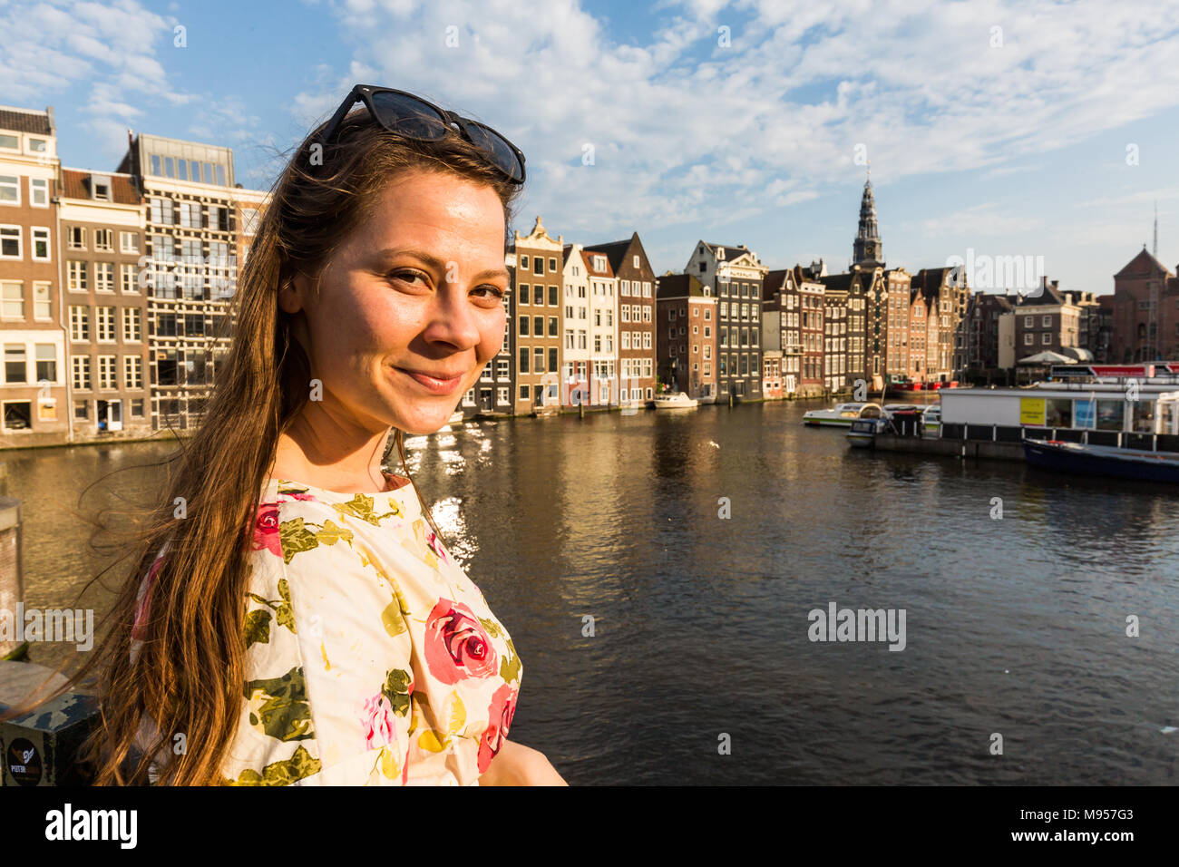 Vista di un turista ragazza sul tramonto a Damrak square in Amsterdam Foto Stock