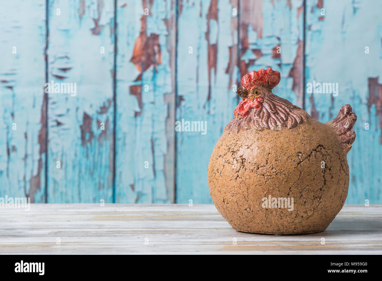 Decorativo pollo rustico con blu sullo sfondo di legno Foto Stock