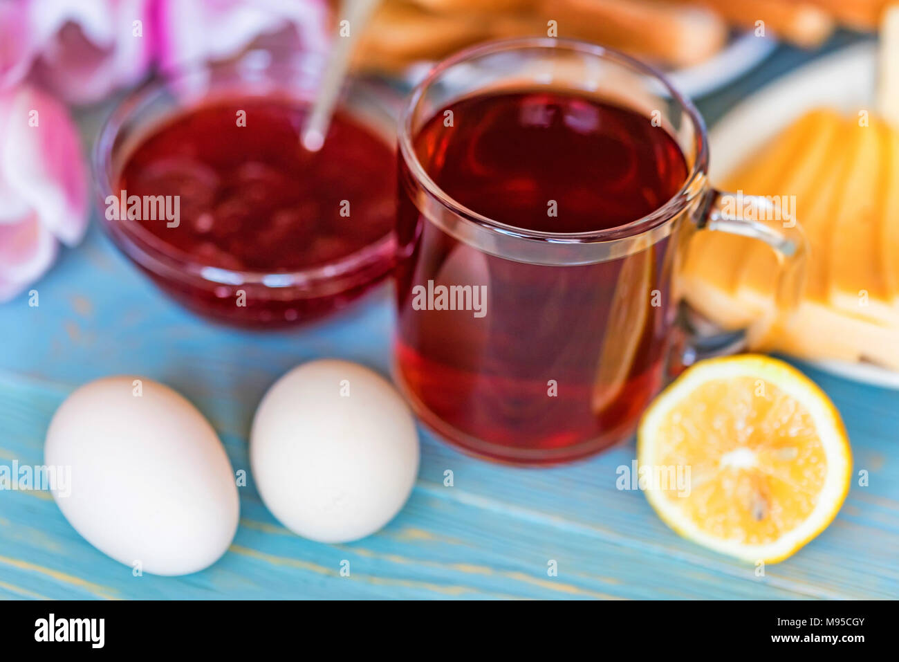 La prima colazione con tè, marmellata e fiori Foto Stock