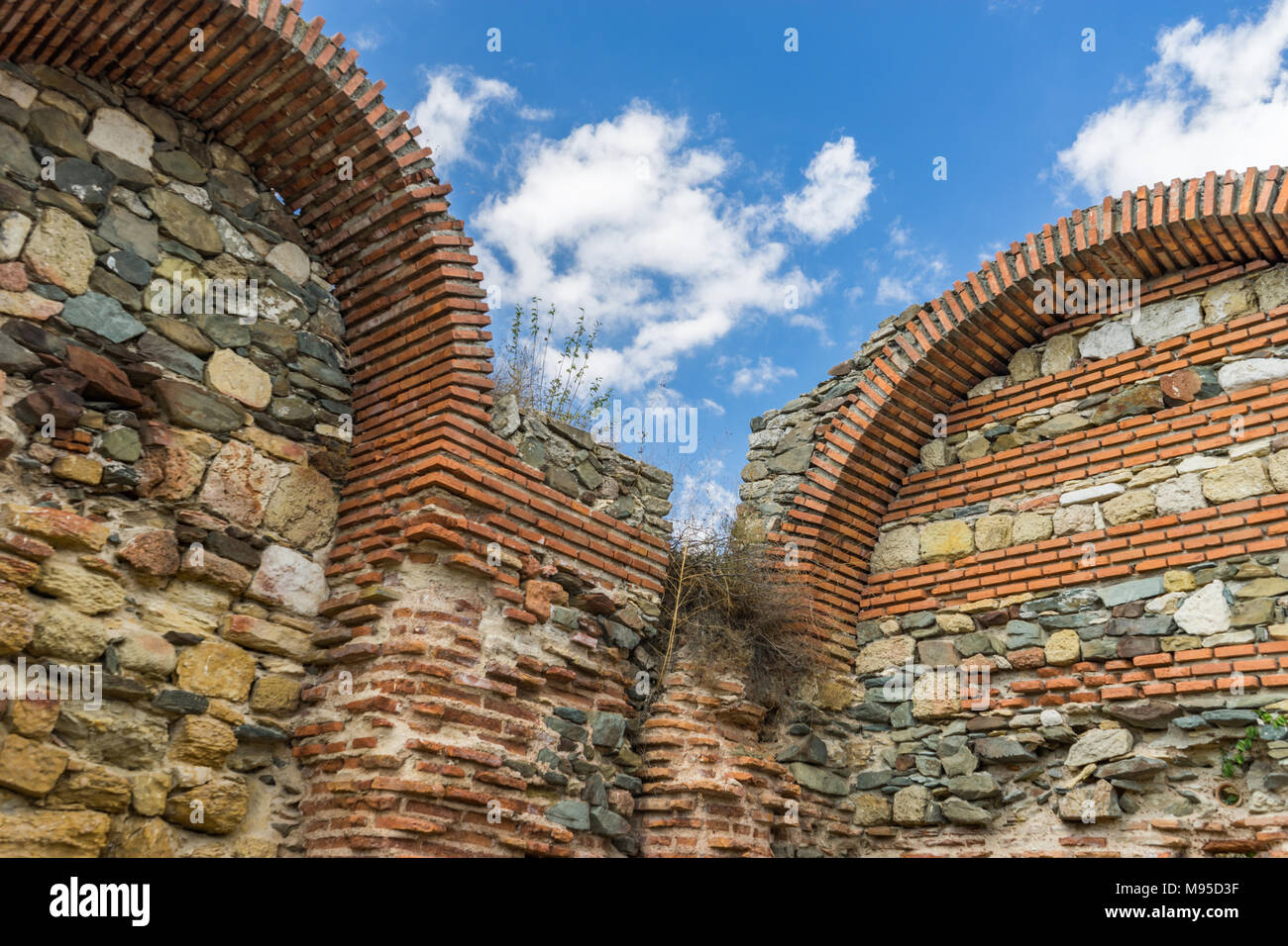 Resti delle mura di pietra con archi di antico castello Histria, Romania Foto Stock