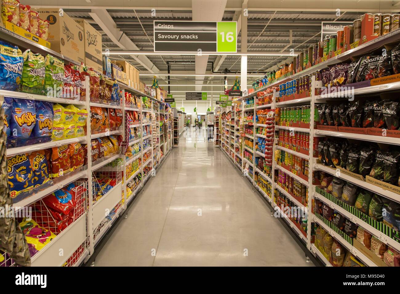 Patatine e salatini sulla piena di scaffali in un supermercato Asda. Foto Stock