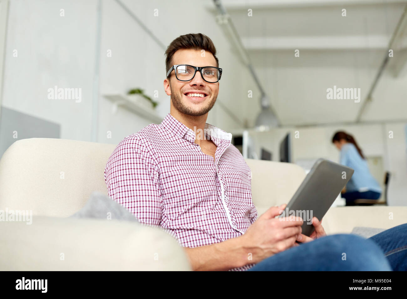 Uomo in bicchieri con tablet pc lavorando in ufficio Foto Stock