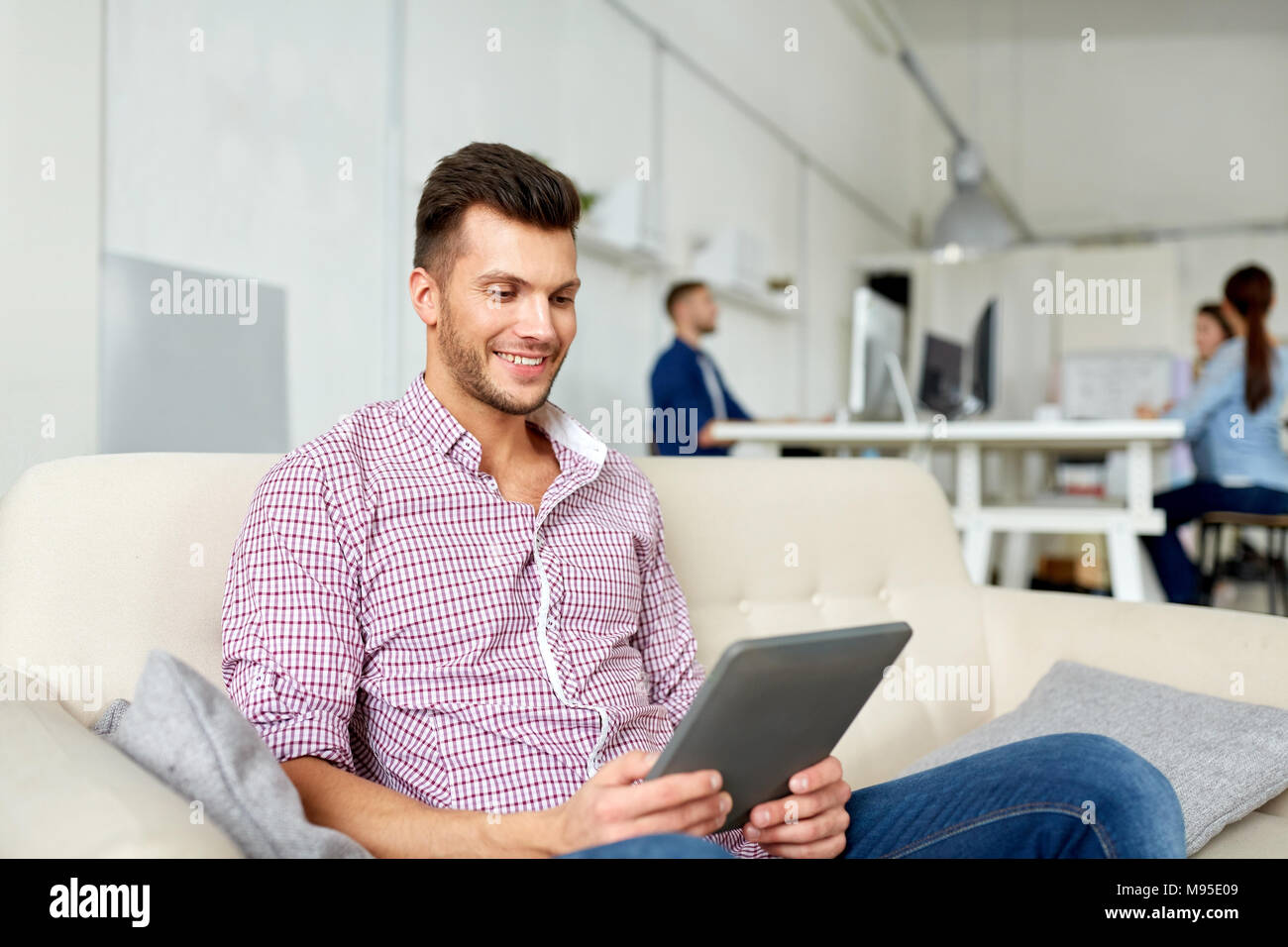 Uomo in bicchieri con tablet pc lavorando in ufficio Foto Stock