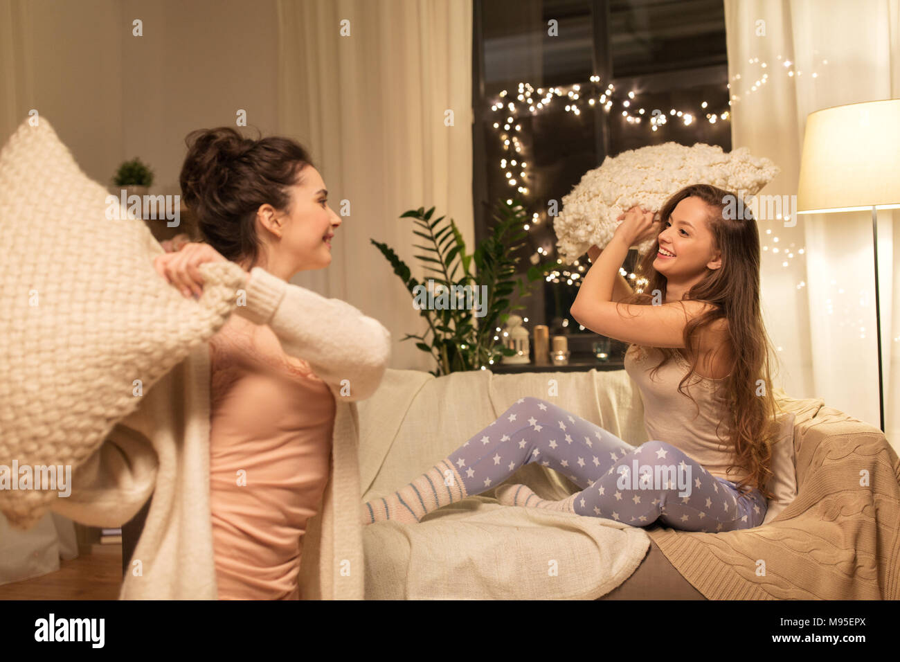 Happy amici di sesso femminile avente cuscino lotta in casa Foto stock -  Alamy