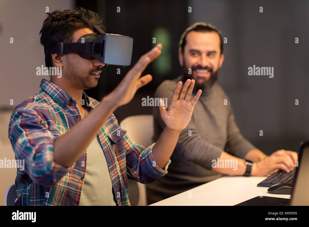 Uomo creativo in realtà virtuale auricolare in ufficio Foto Stock