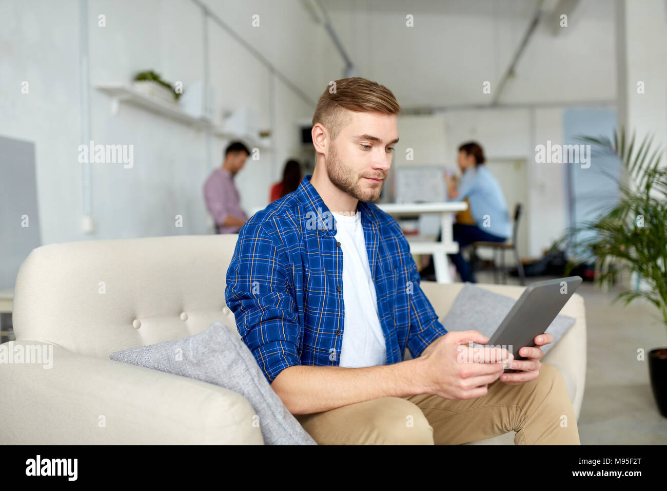 Uomo con tablet pc lavorando in ufficio Foto Stock